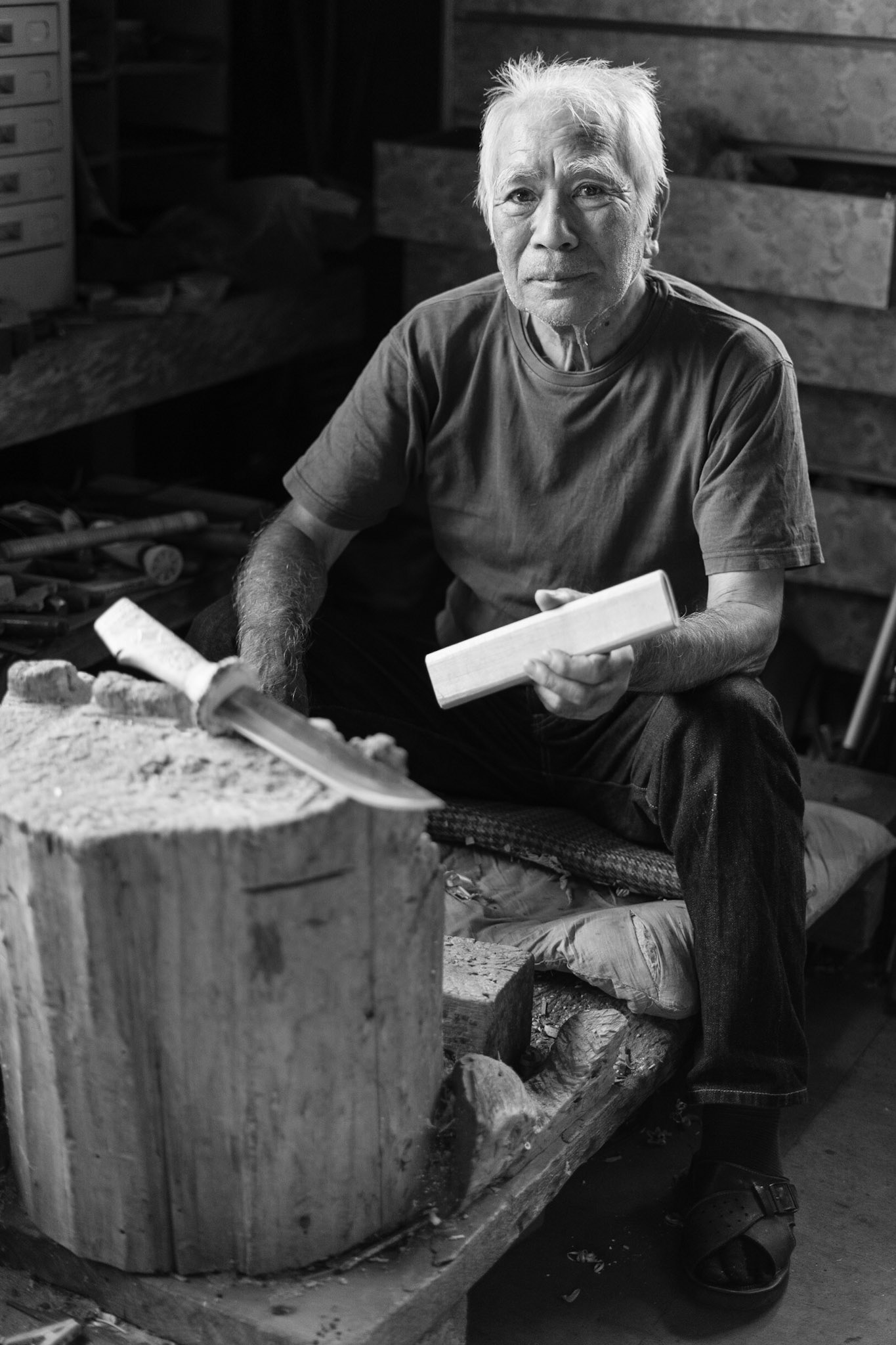 Ainu Craftmans Tahachi Urakawa sitting at his workbence