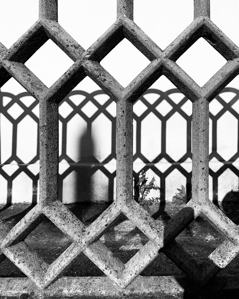 Concrete fence, shadows and geometric shapes