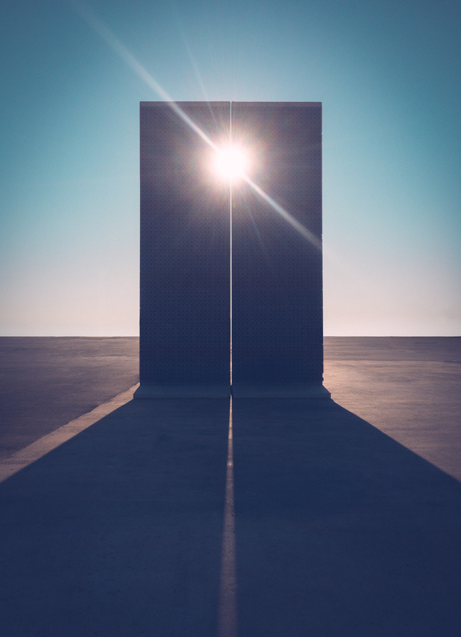 Sun shining through two black monolith