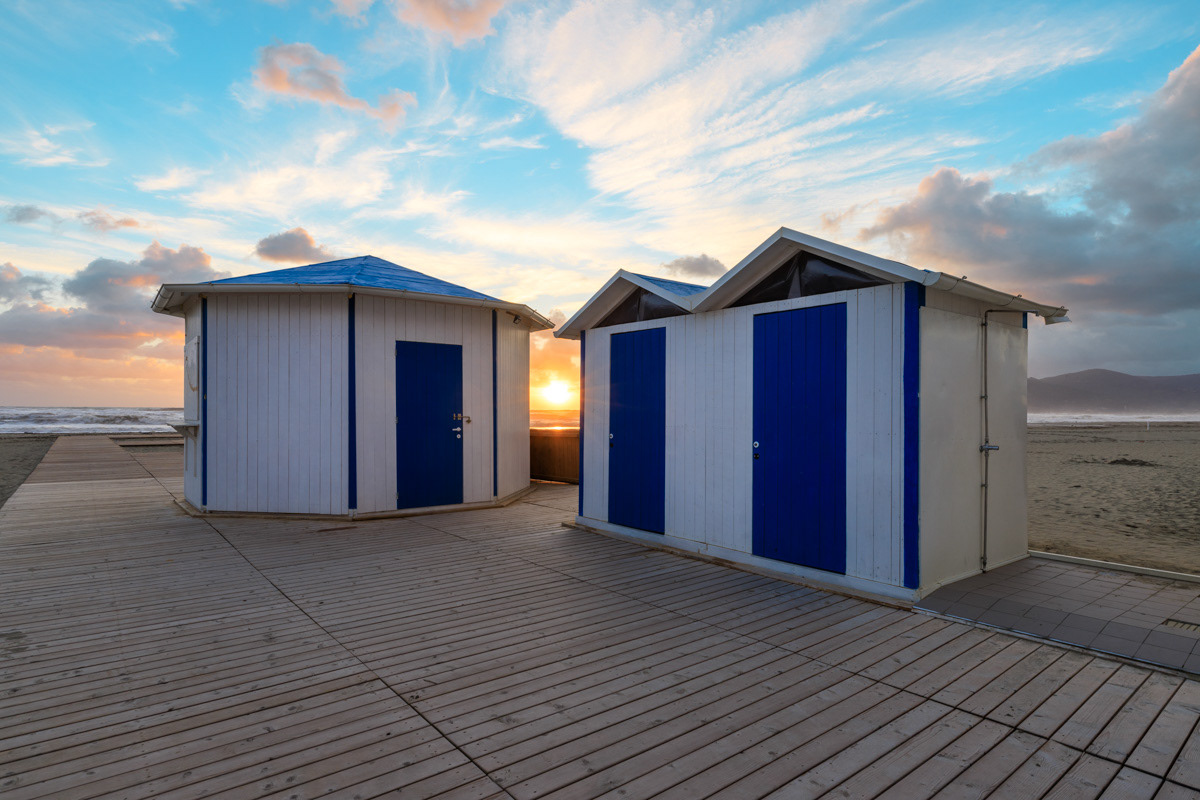 Bathing-huts on a beach during a sunset in Marina di Carrara, Italy