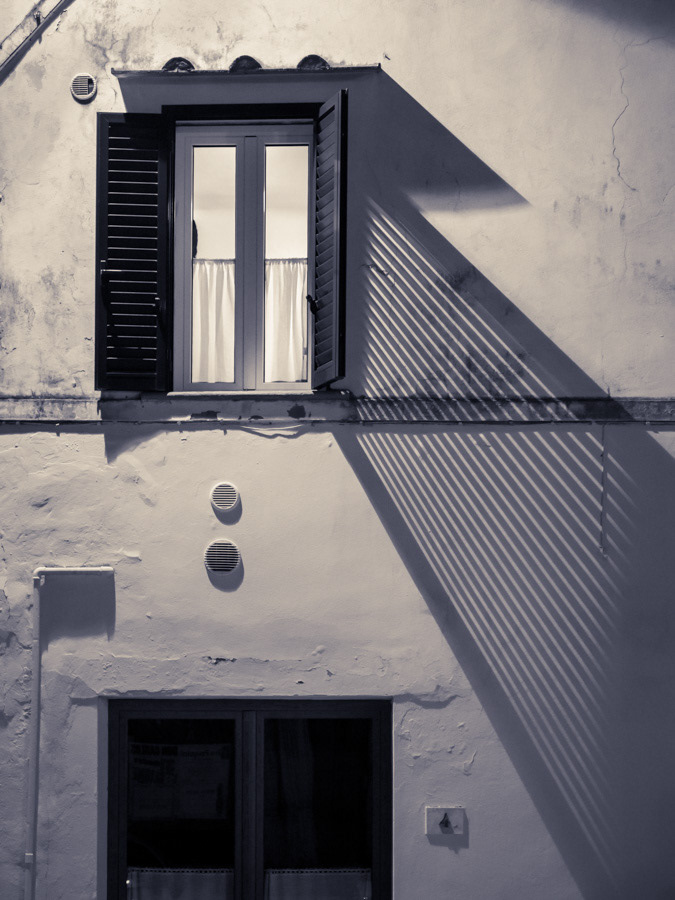 Window and shutter projecting a long shadow at night (night, monochrome photography)