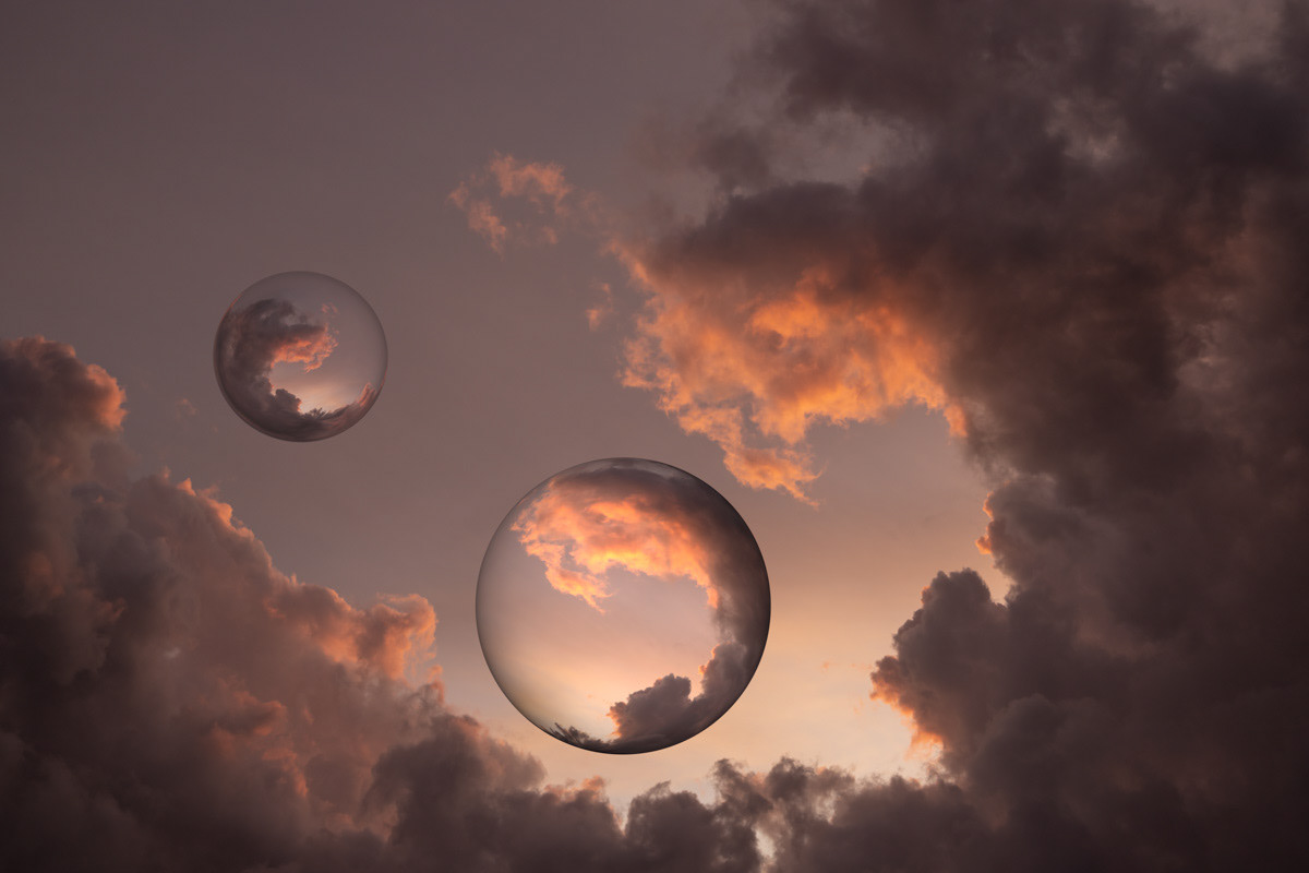 Two reflective spheres in a cloudy sky