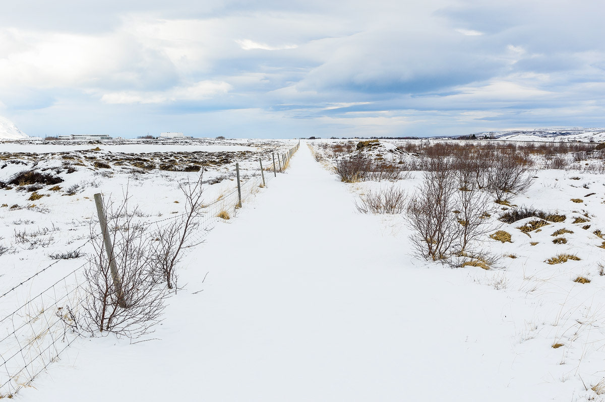 Een eindeloze weg in het winterse landschap van het Noorden van IJsland