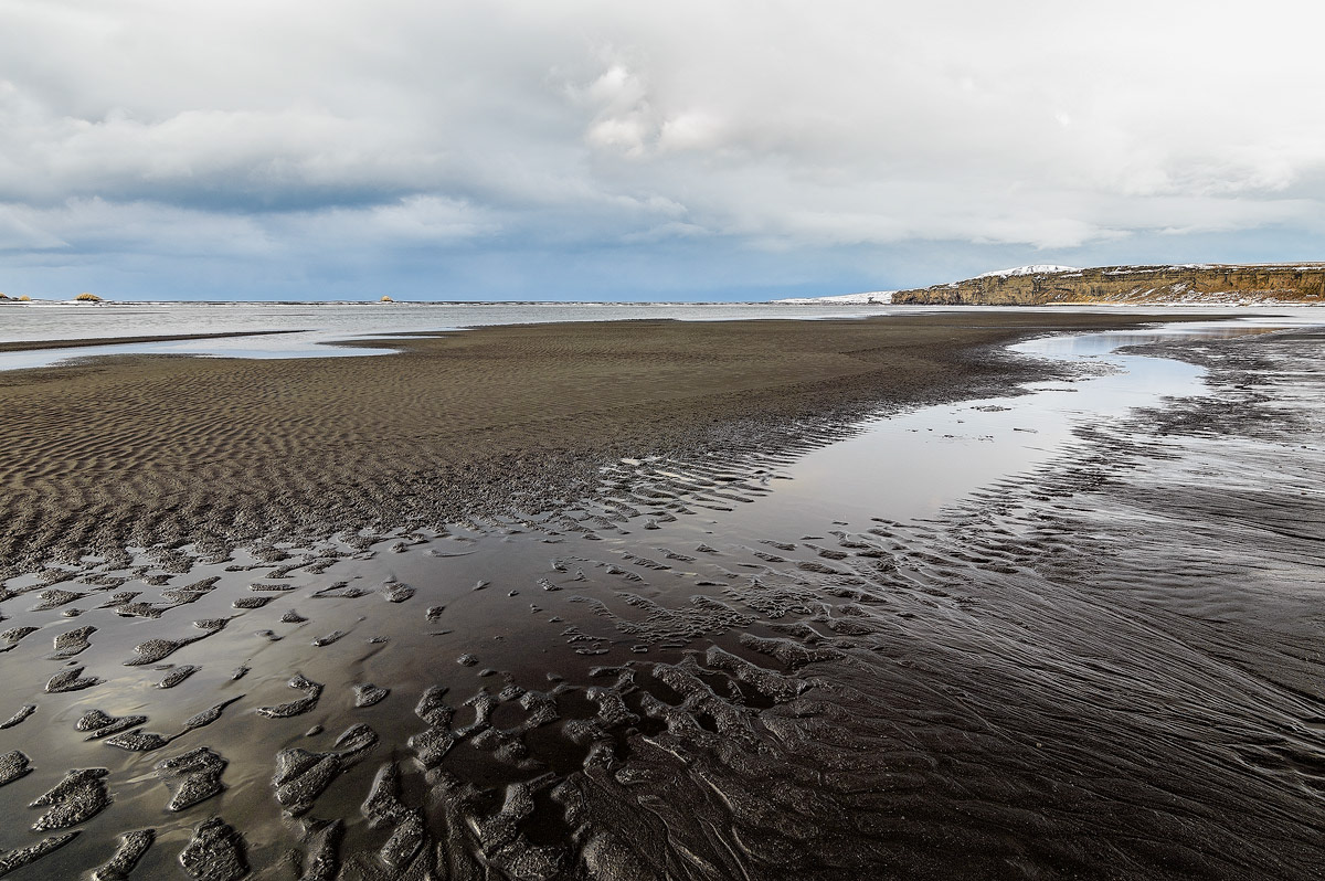 Zandstructuren op een vulkanisch strand in het Noorden van IJsland