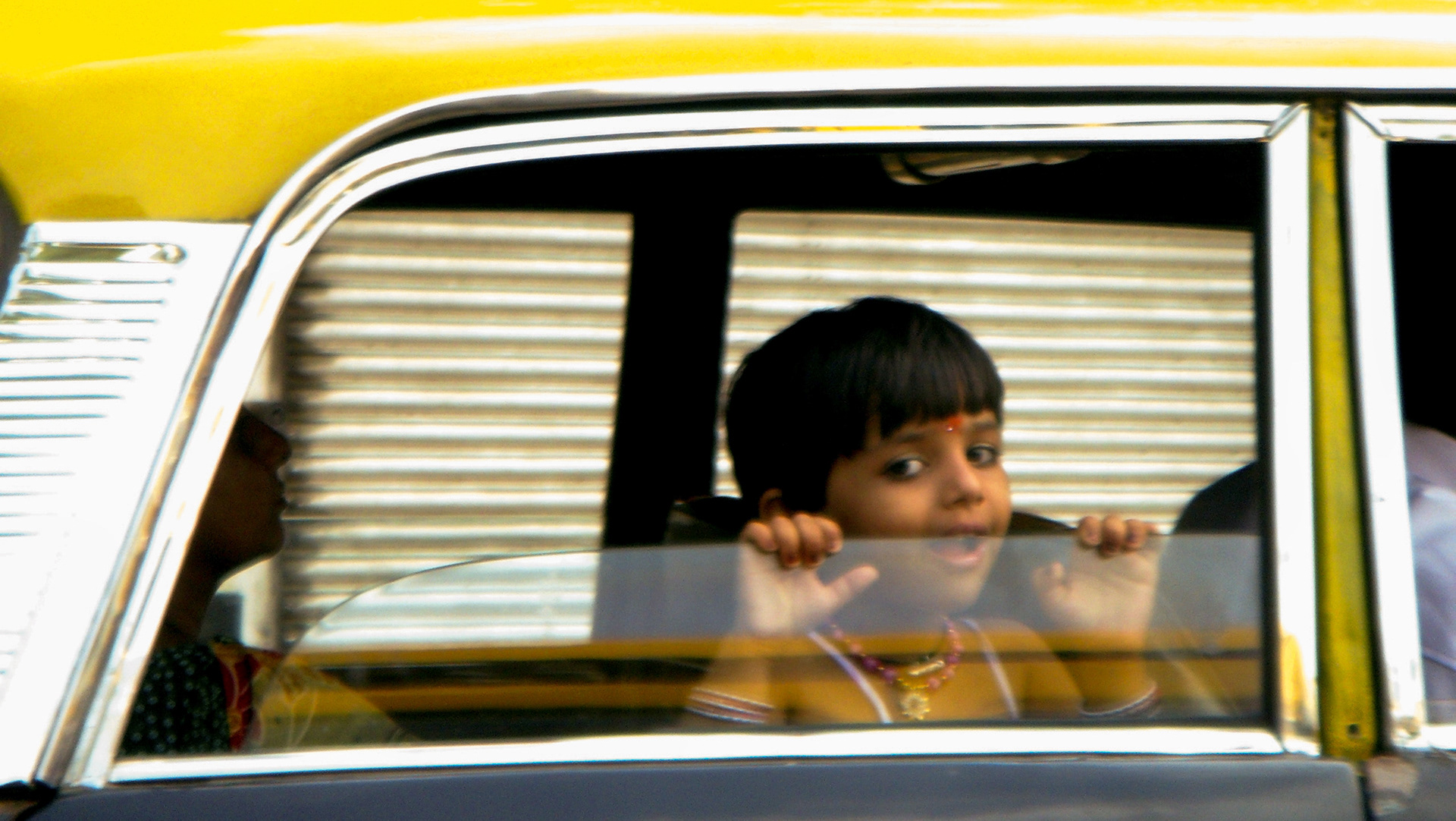 Spontaneous photograph of a young girl in a taxi in India by Bucchianeri.
