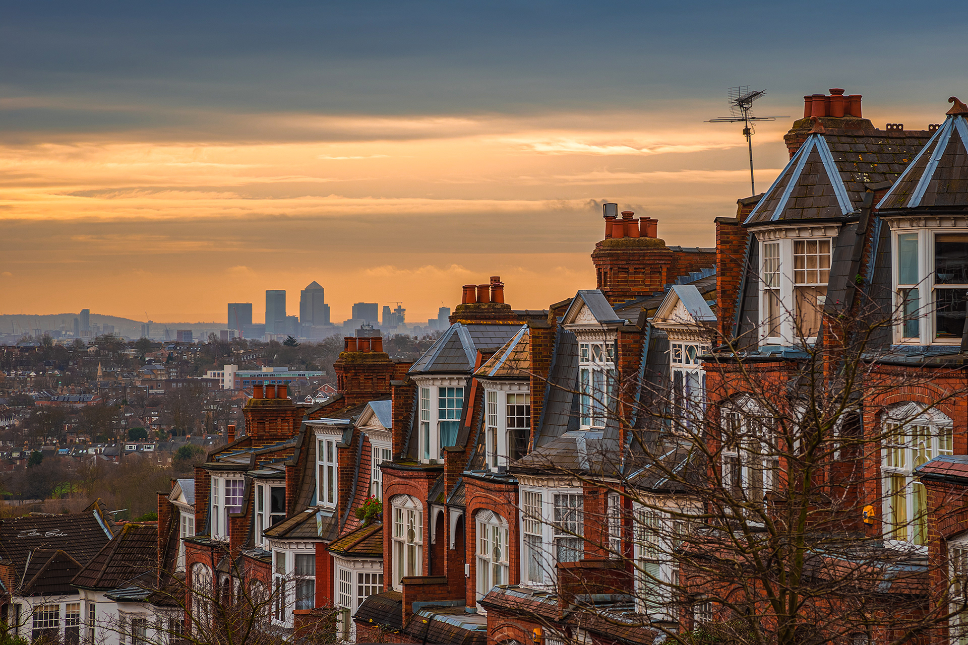 Old Victorian houses at Muswell Hill with Canary Wharf and winter sunrise at background