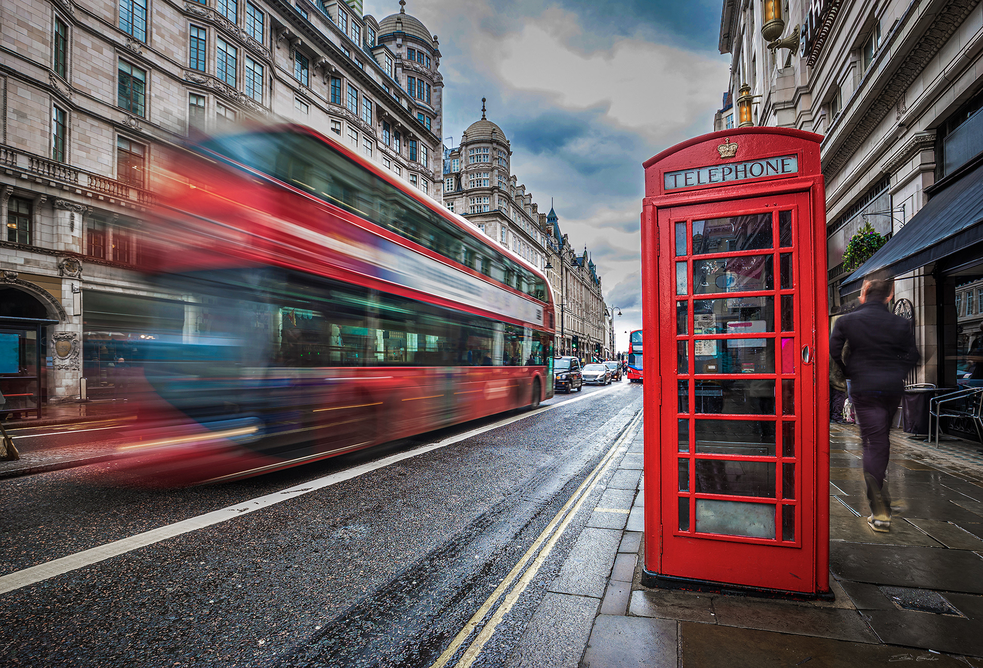 Red Phone Booth with Double-Decker bus on the move