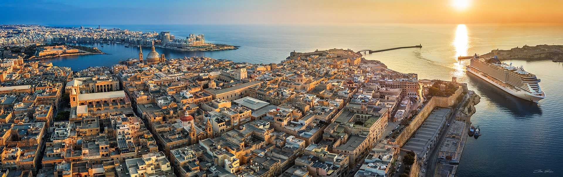 Valletta with a Cruise ship entering the Grand Harbour at sunrise