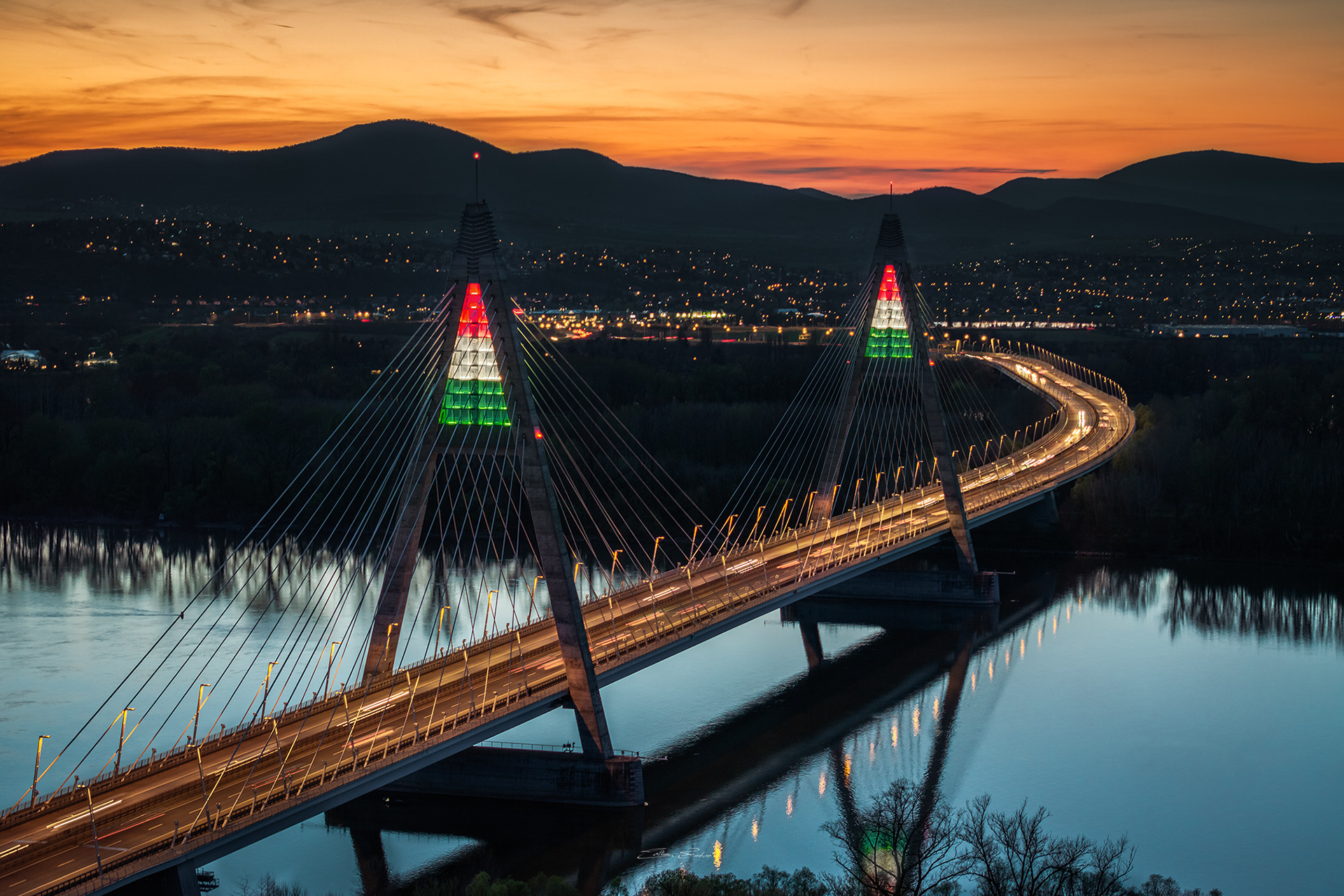 Megyeri Bridge in national tricolor lights at sunset