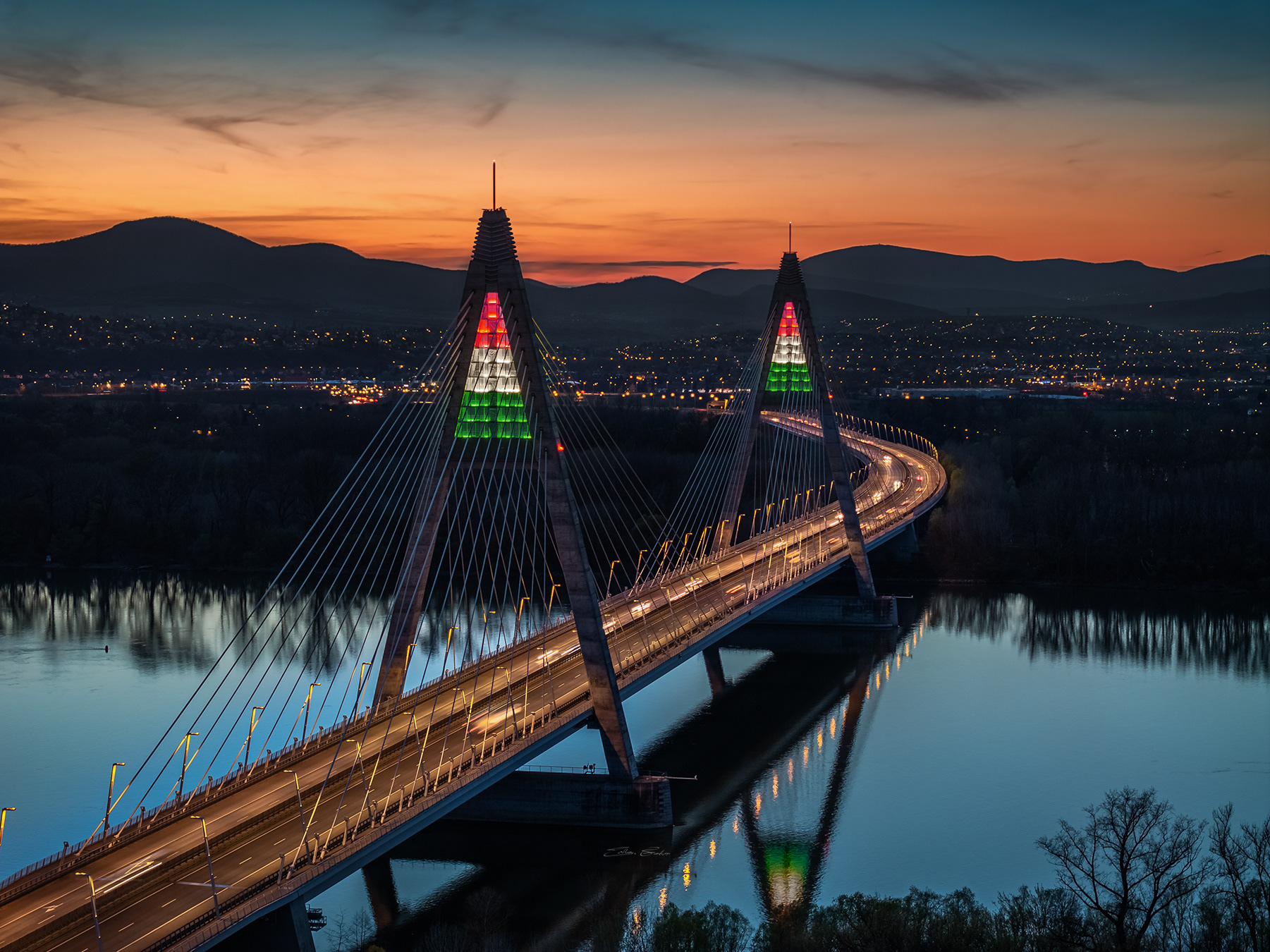 Megyeri Bridge in national tricolor lights at sunset