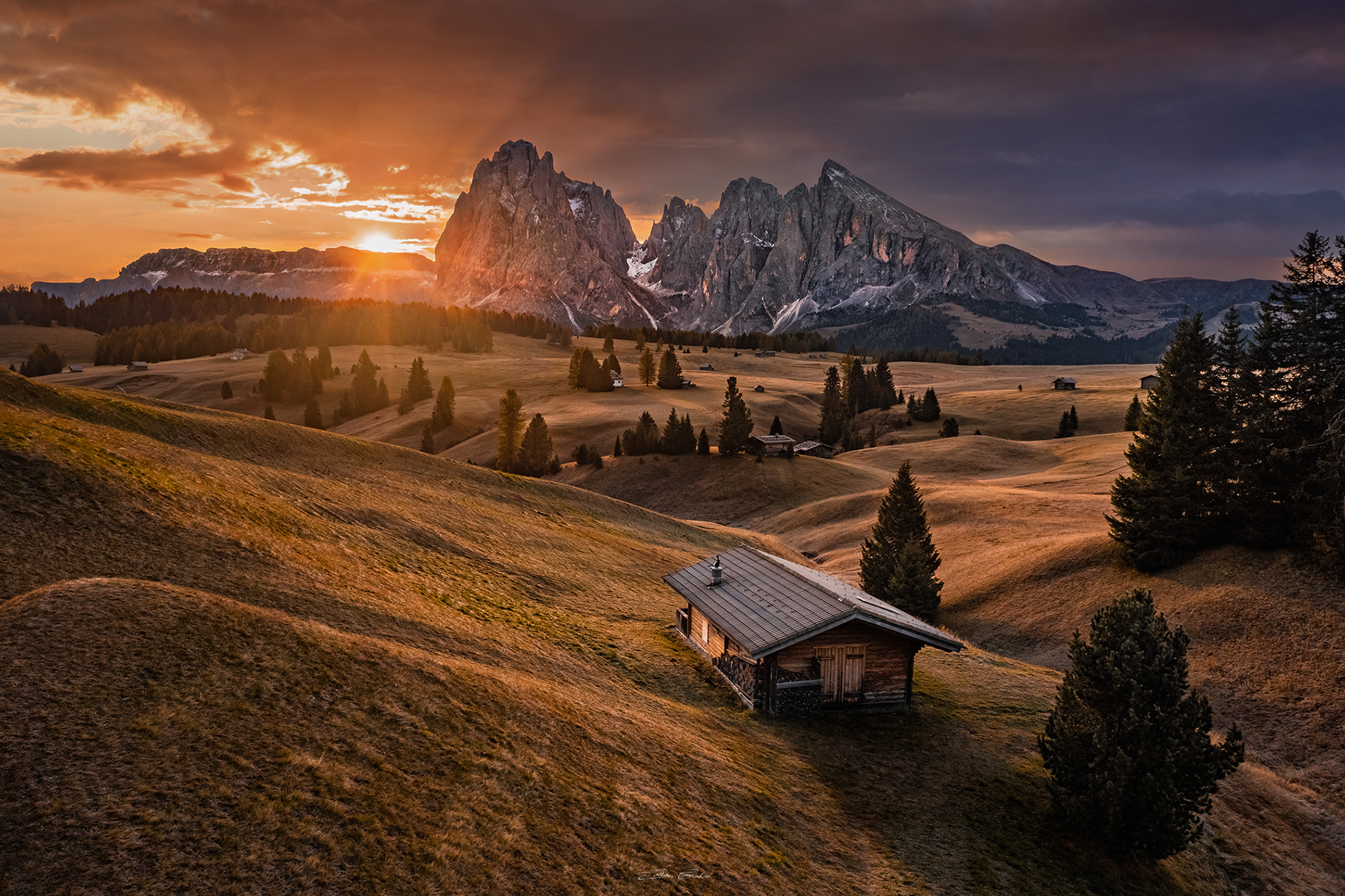 Sunrise over Seiser Alm (Alpe di Siusi) with wooden chalets
