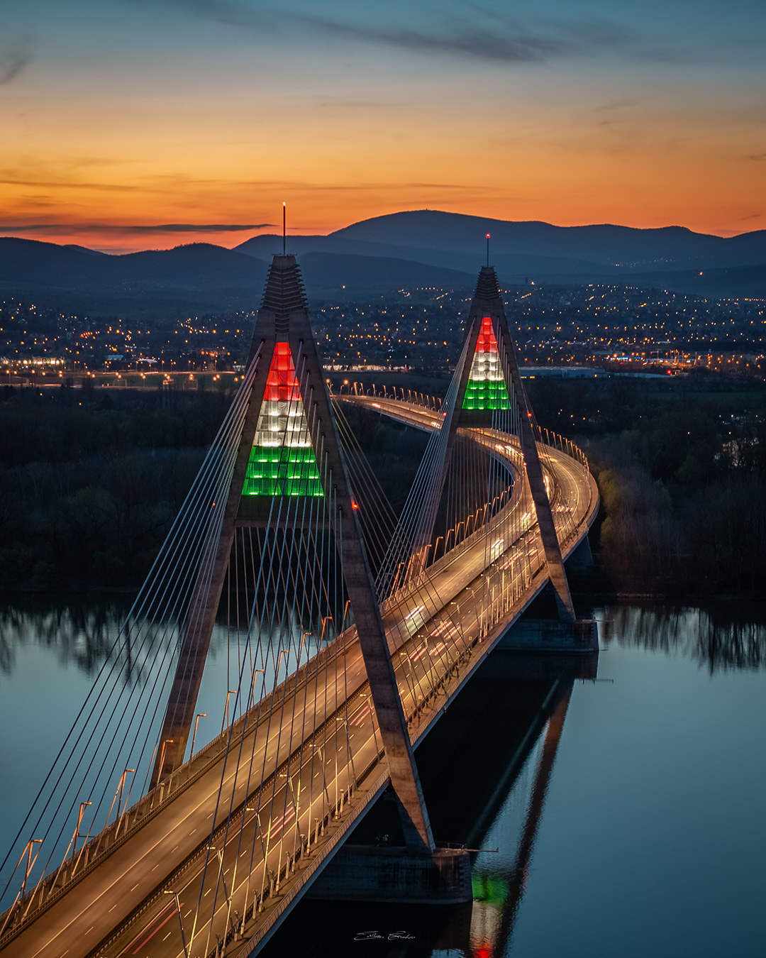 Megyeri Bridge in national tricolor lights at sunset