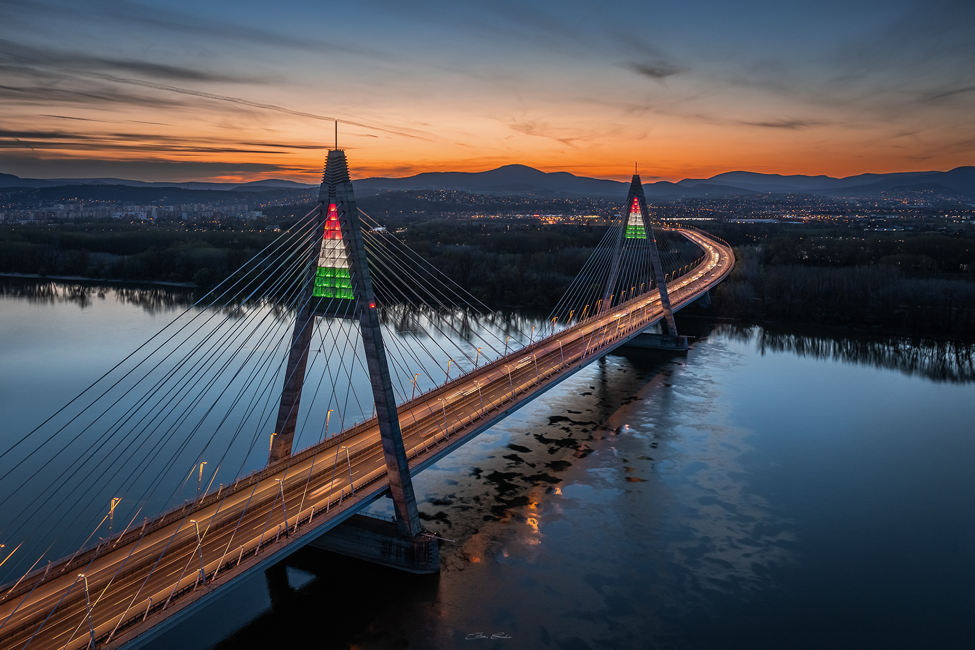Megyeri Bridge in national tricolor lights at sunset