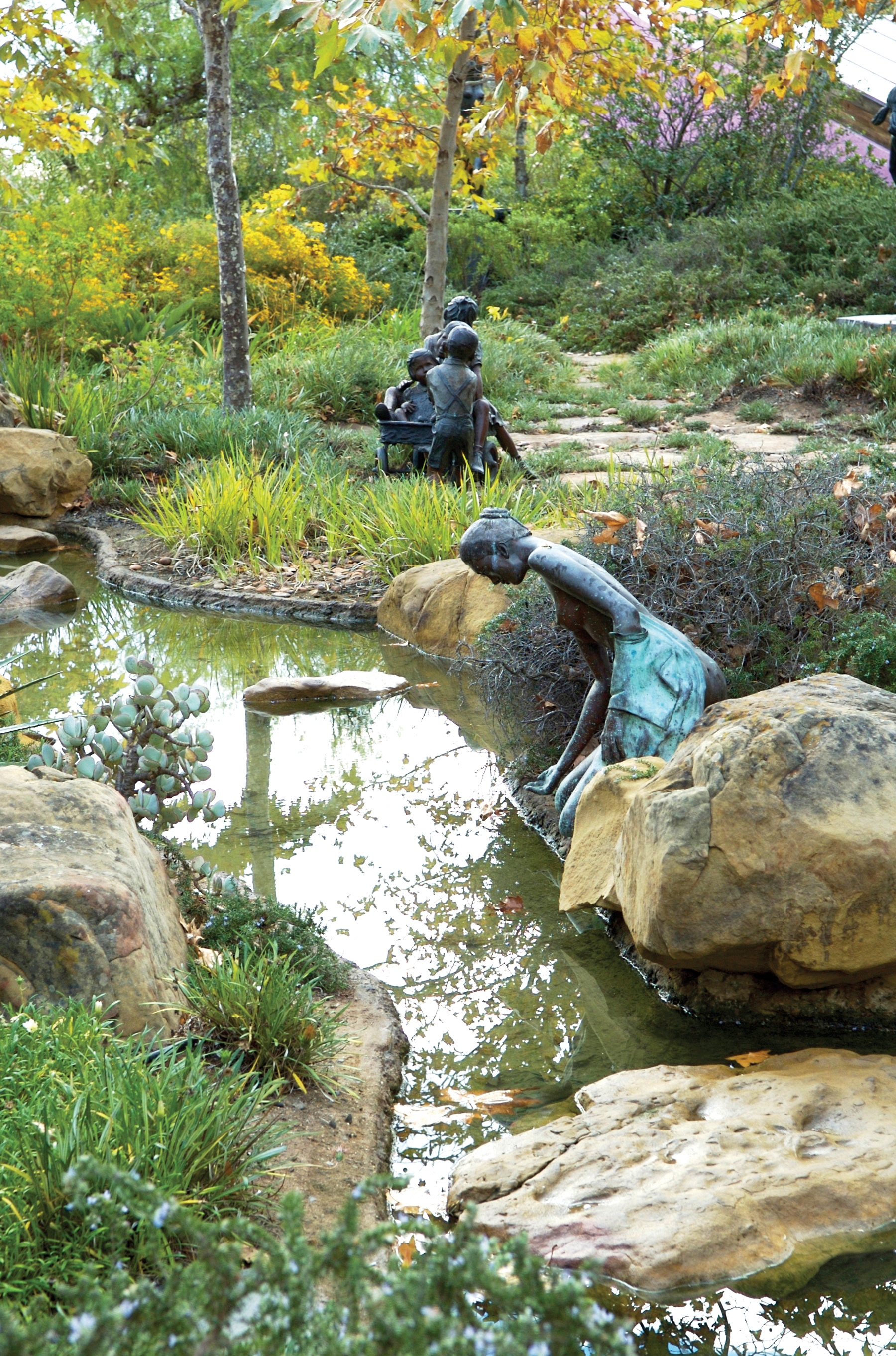 a stream with several bronze sculptures