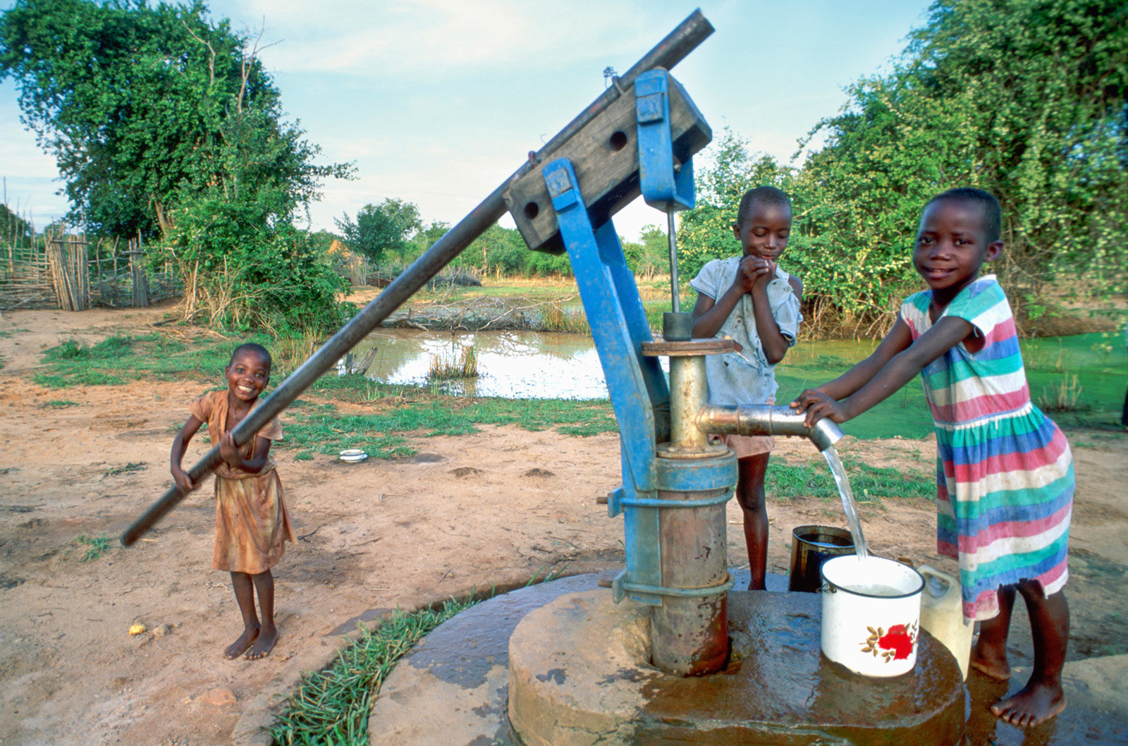 BaTonga girls pumping water from the village well. Zimbabwe