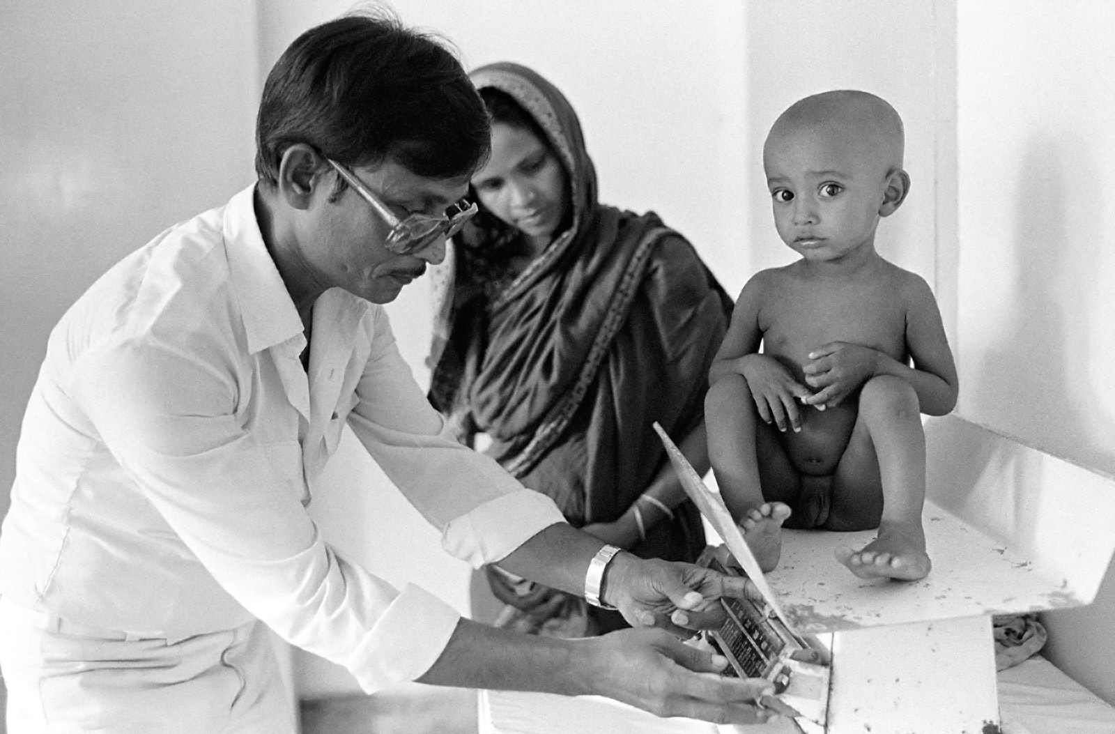 Doctor weighing child in the Child Nutrition Unit. Dhaka, Bangladesh