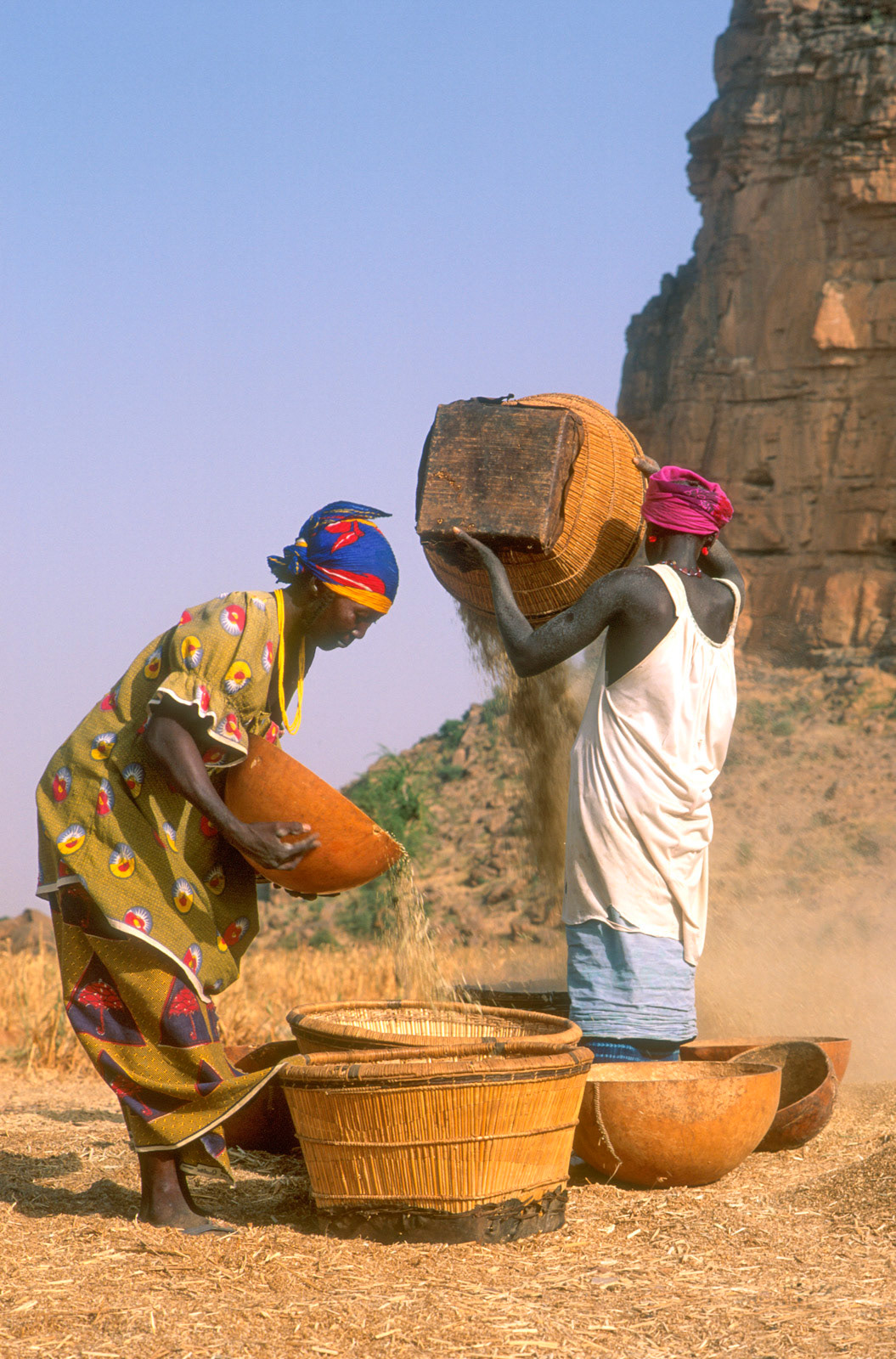 Dogon women winnowing millet in Hombori, Mali
