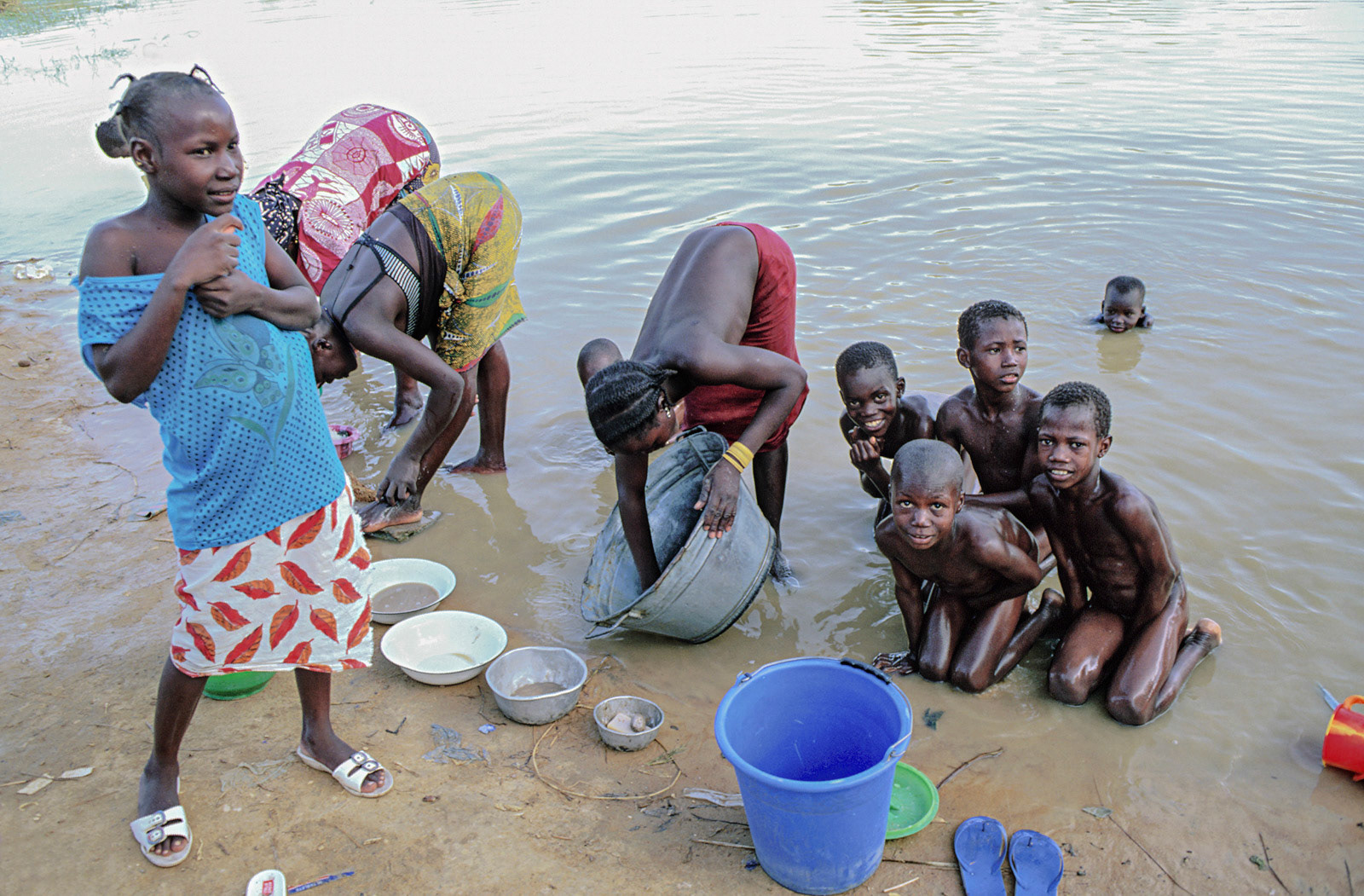 Girls working, boys playing, Bore. Mali