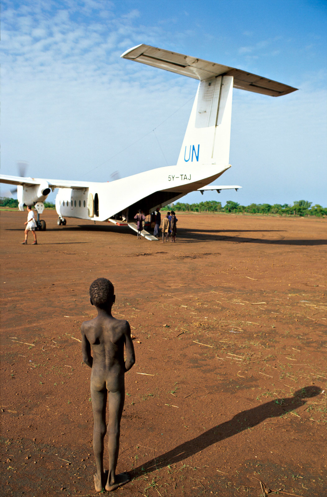 Dinka boy watching a UN food aid plane unload. South Sudan