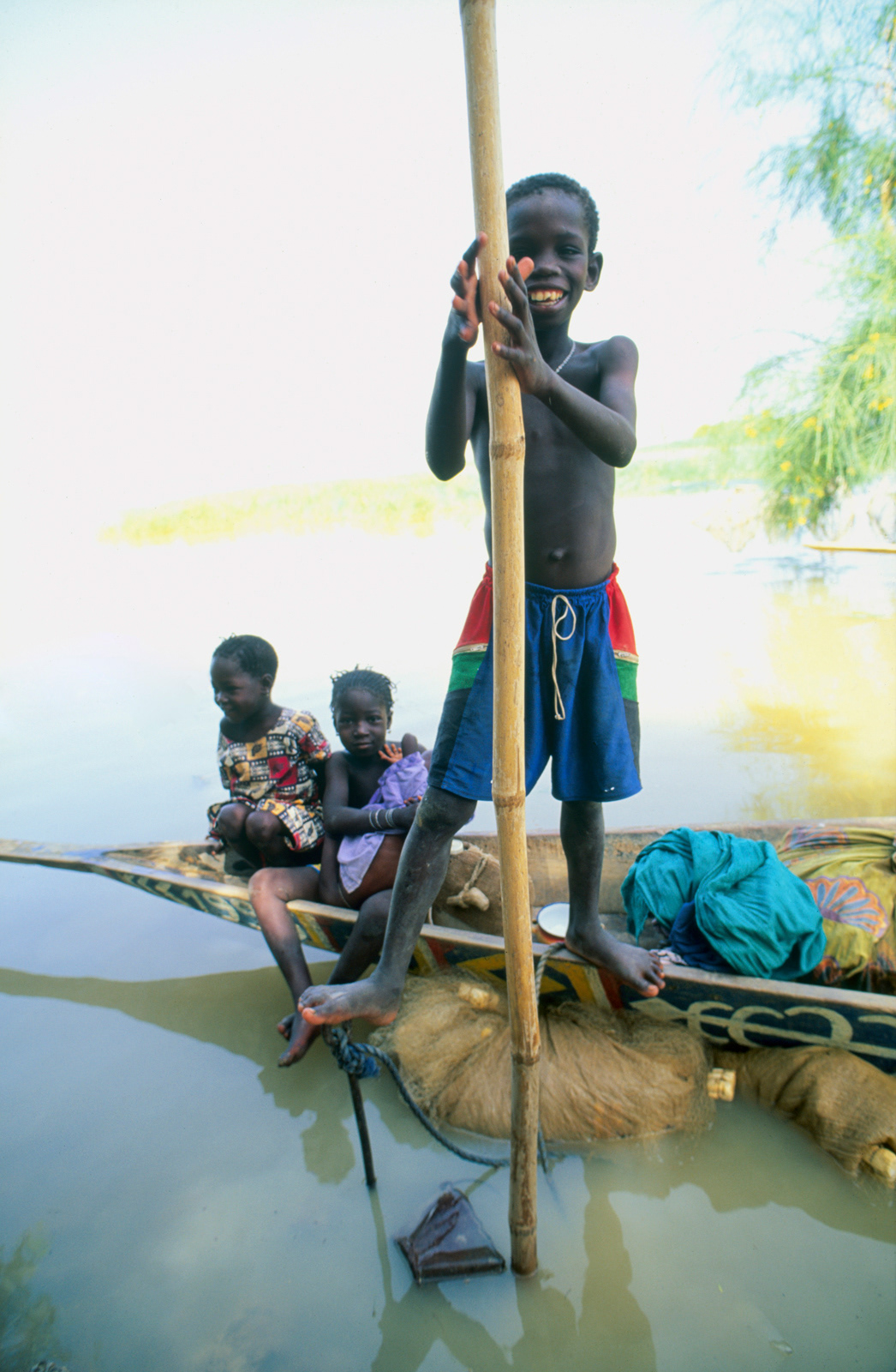 Children playing on a pirogue (canoe) on the Niger River. Mali