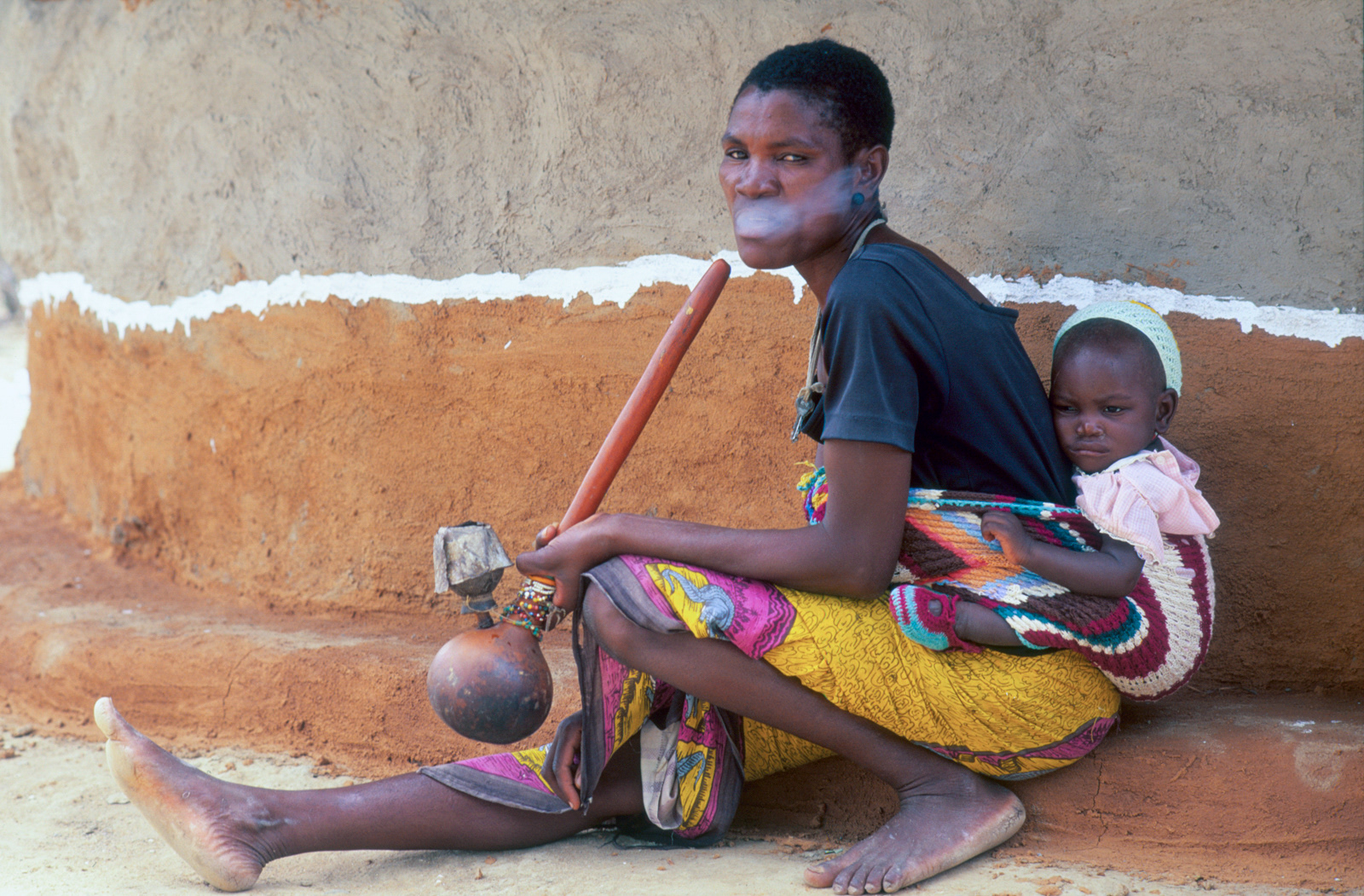 BaTonga woman smoking a gourd water pipe. nr Binga, Zimbabwe