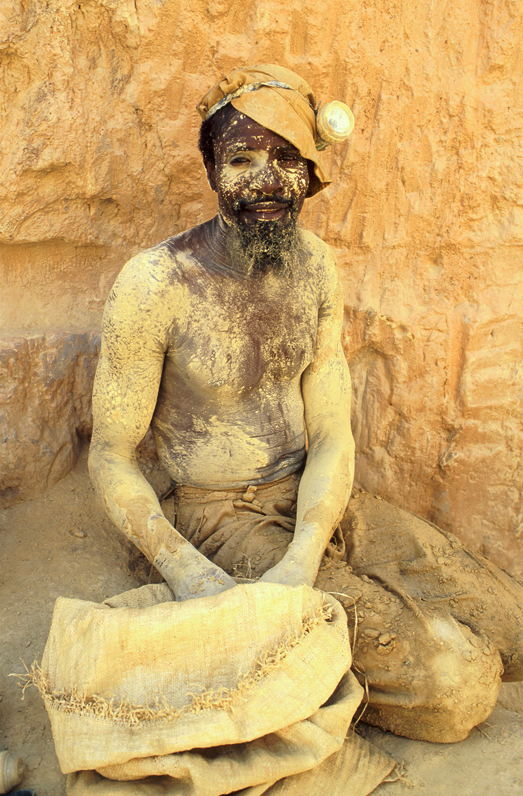 Goldminer with his sack of ore. Essakane, Burkina Faso