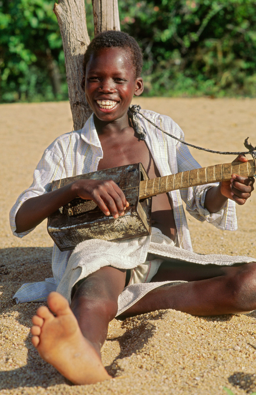 Playing a homemade oil can guitar on the shores of Lake Malawi
