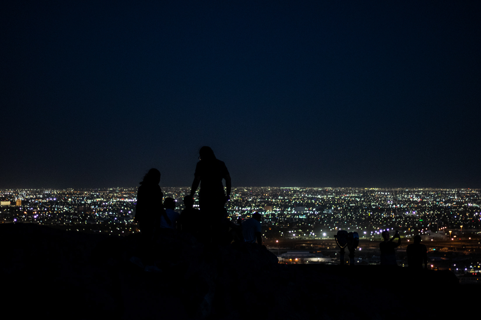 Individuals overlook Ciudad Juárez, Mexico from Rim Road Overlook in El Paso, Texas on May 11. 