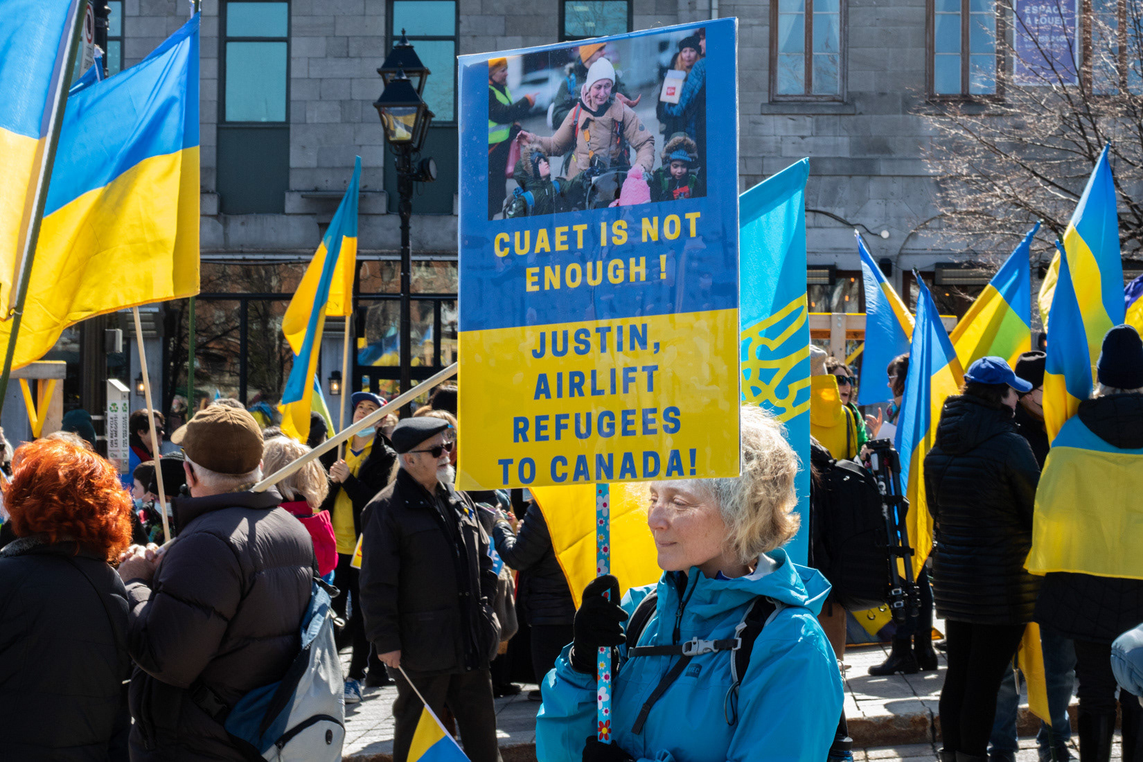 A protester holds a sign urging Canadian Prime Minister Justin Trudeau to airlift Ukrainian refugees to Canada at a rally in support of Ukraine at Place Jacques-Cartier Square in Old Port Montreal, on April 2. 