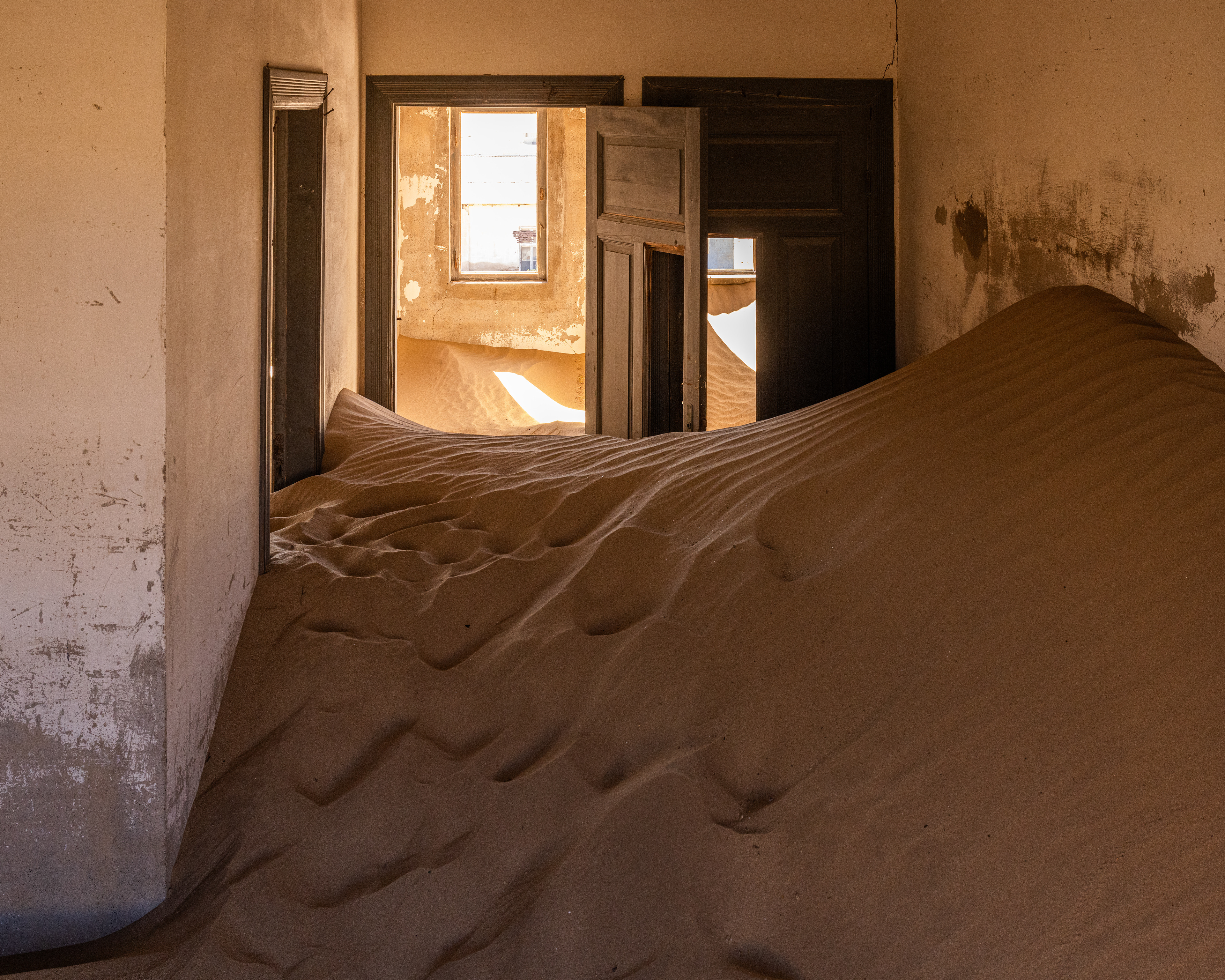 Kolmanskop III - The town started to decline in WWI as the diamond field started to deplete. When a richer diamond-bearing deposits were discovered 270km to the South in 1928, inhabitants abandoned their homes and possessions in a rush to the new pickings. Kolmanskop, Namibia.