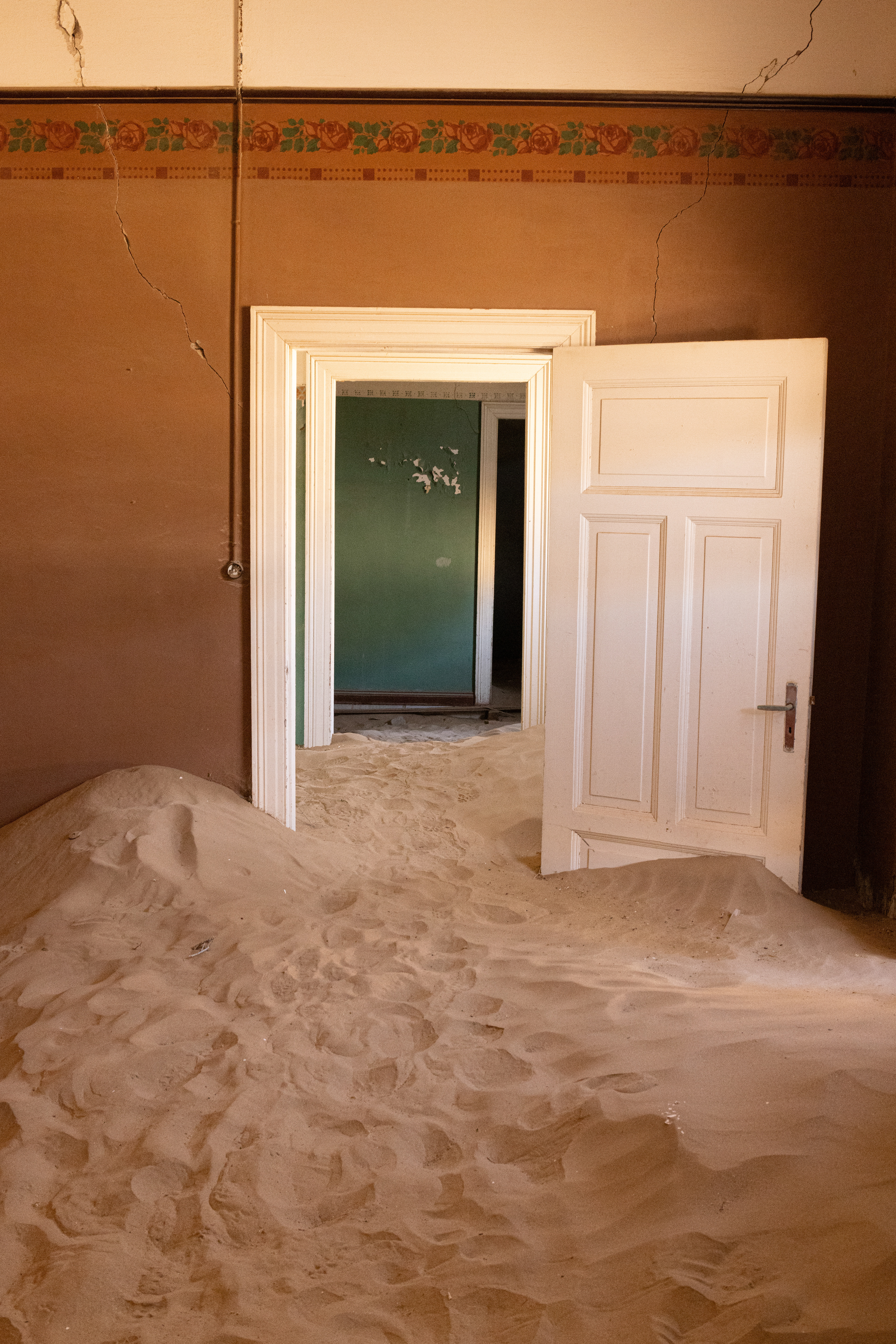Komanskop VII - With broken windows and doors, nature is left unfettered in its mission to reclaim its territory, depositing sand dunes inside the buildings. Kolmanskop, Namibia.