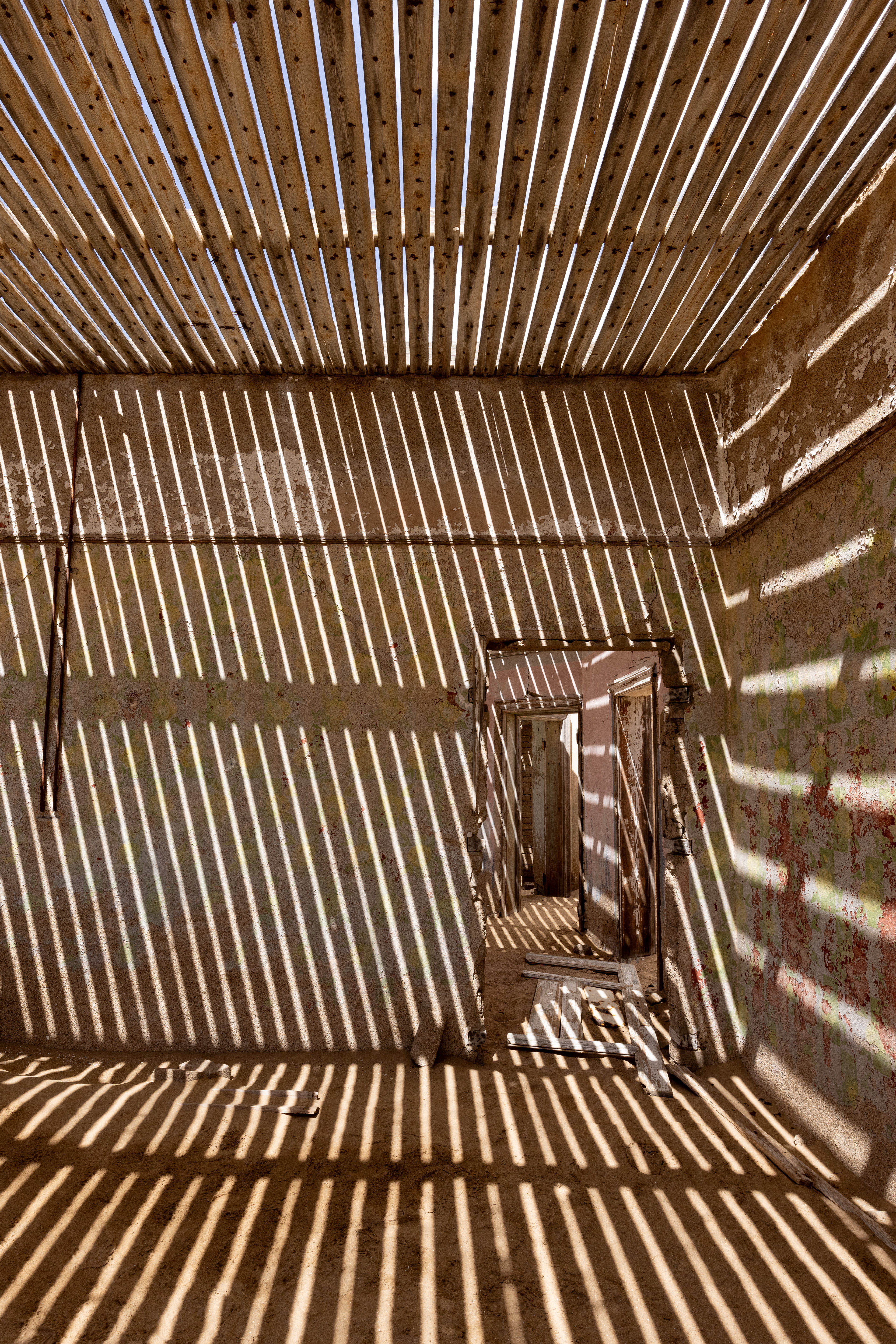 The Zebra Room - With the roof tiles gone, the rafters provide an almost surreal effect. Kolmanskop, Namibia.