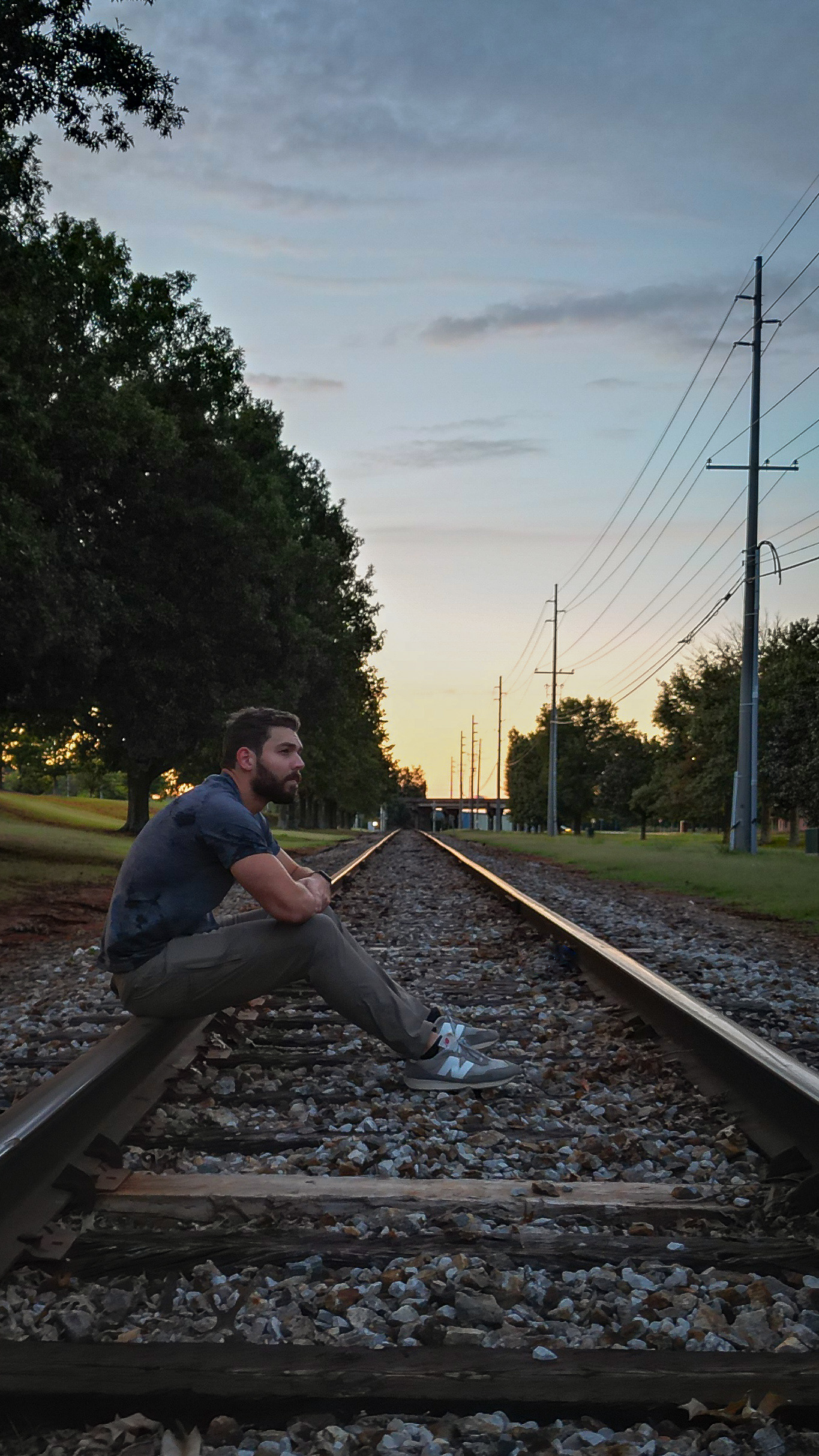 Marty Stange using a drone to pose for a self portrait on train tracks during sunset