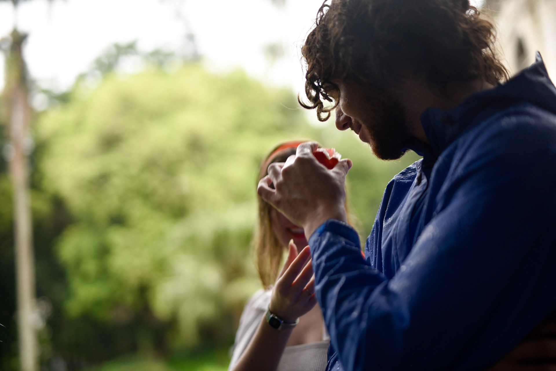 smelling a red fruit from the ground