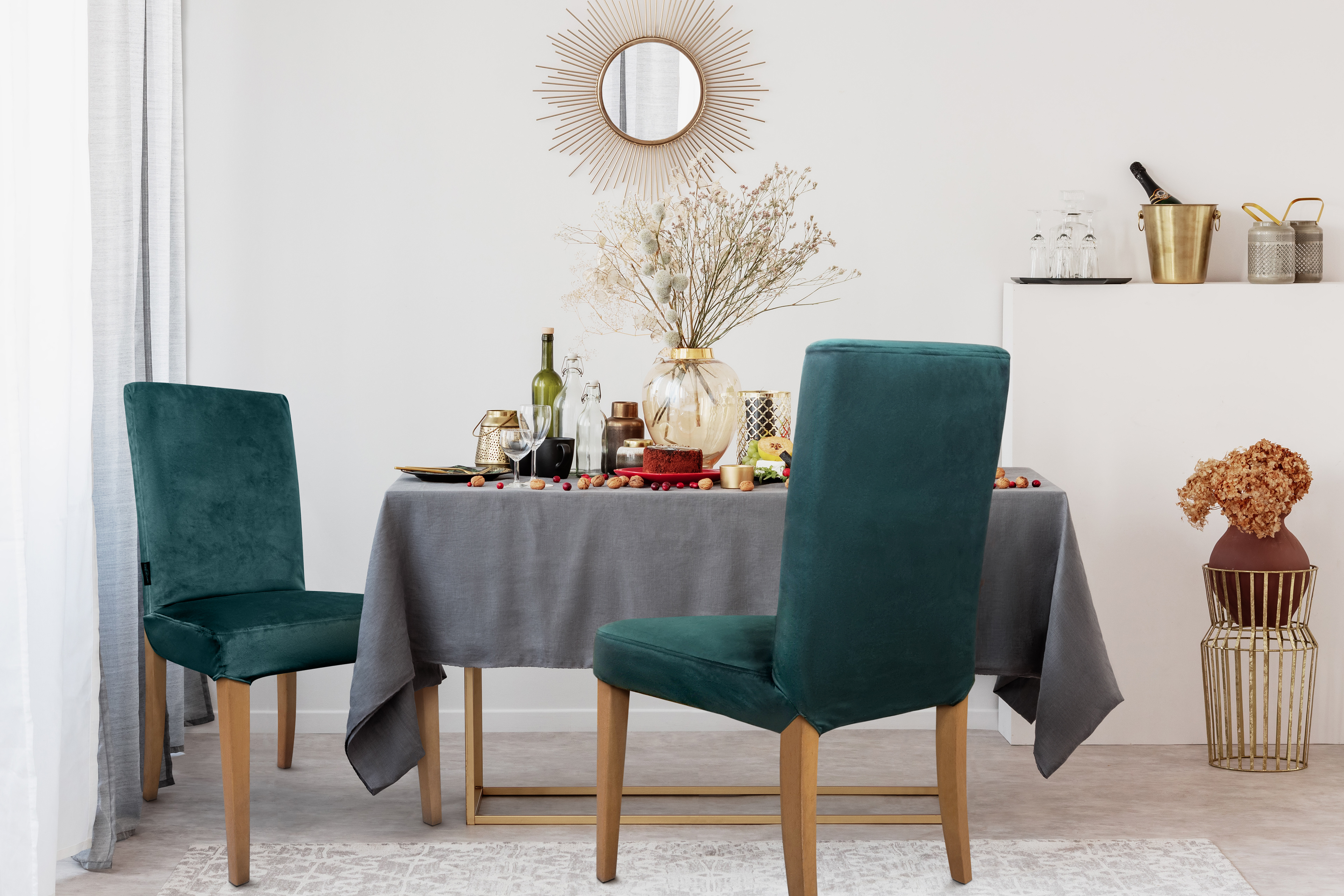 Modern kitchen in cream and grey colors with 2 chairs with dark emerald green velvet covers.