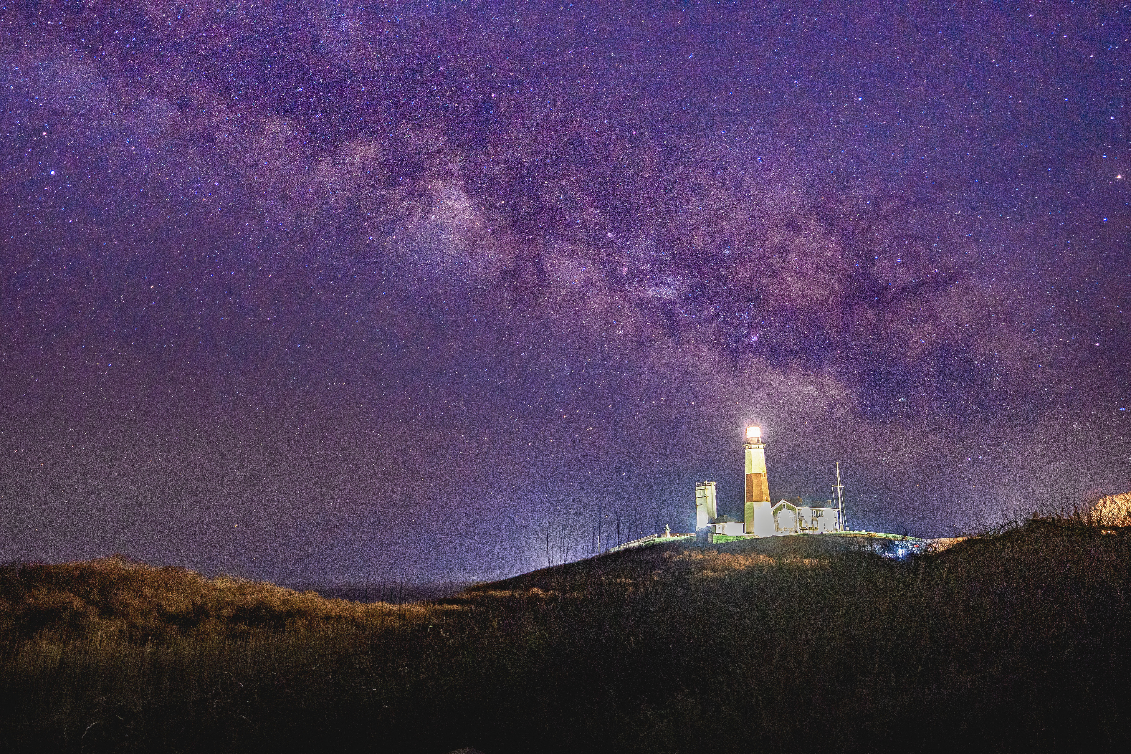 Montauk Lighthouse is brightened up by night sky it rests below. Taken in Montauk, NY.