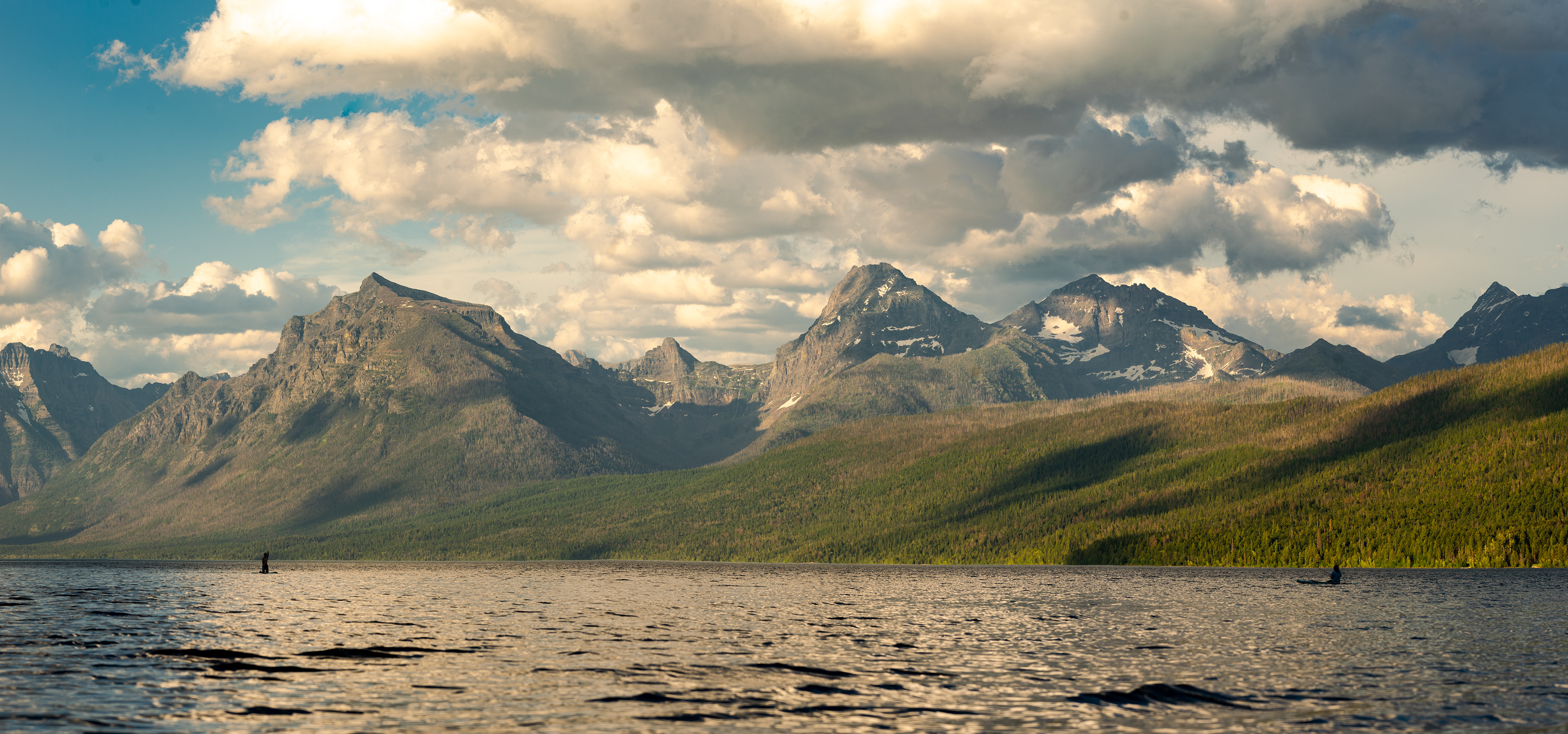 Two paddleboarders/fisherman, take on Lake McDonald from the chance at some rainbow trout. Glacier National Park