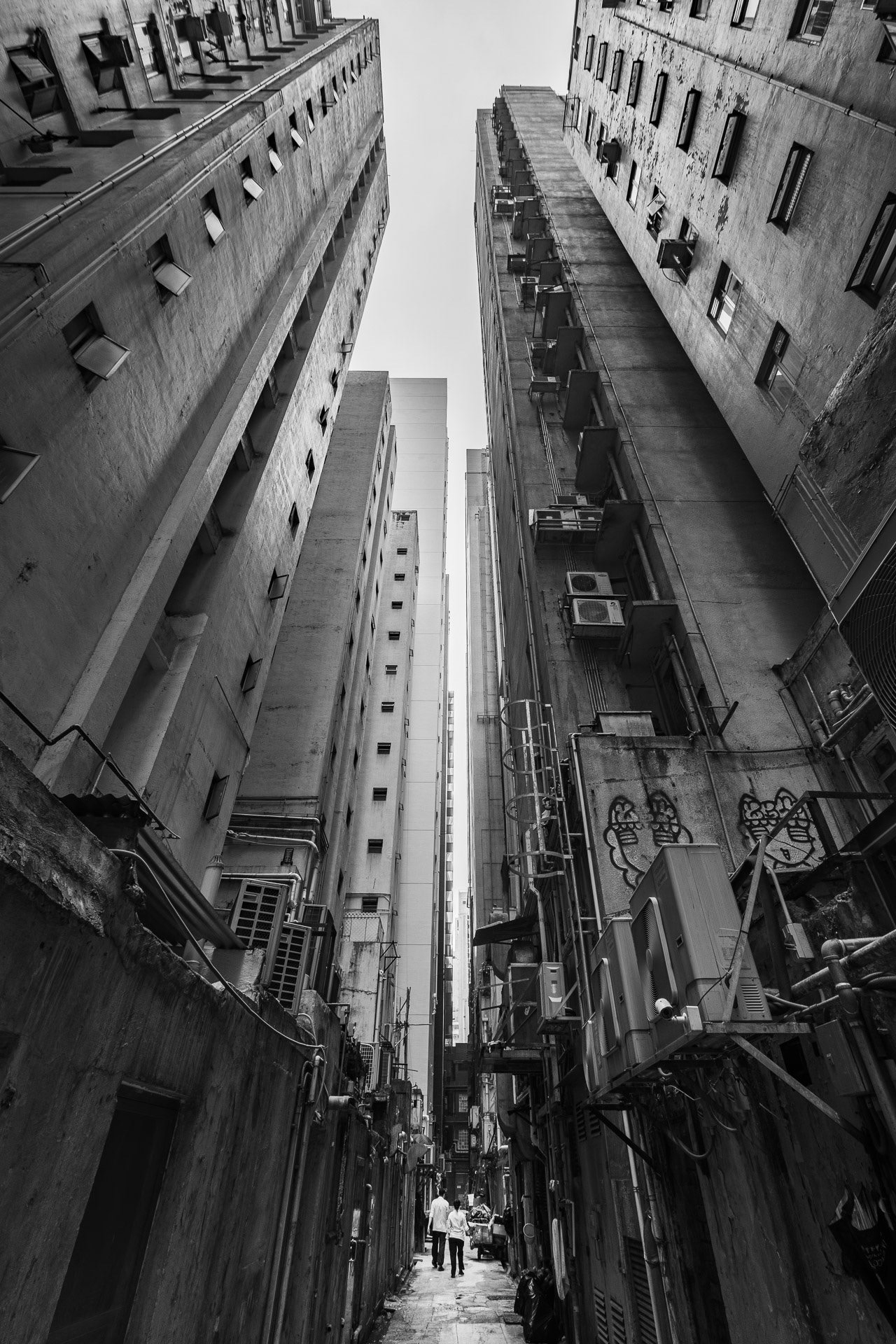 Back alley with pedestrians in Causeway Bay, Hong Kong during the day (black and white photography)