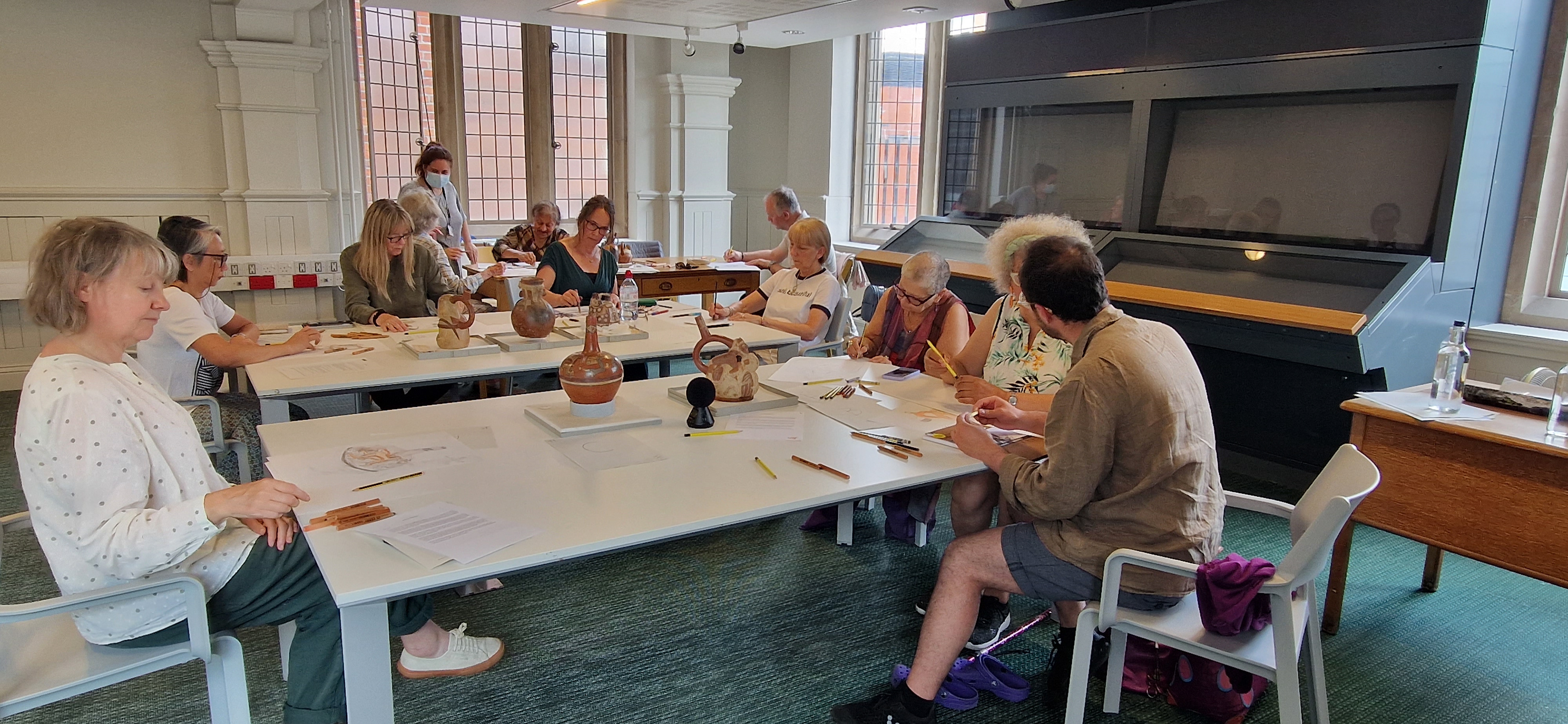 mature adults drawing at Manchester Museum