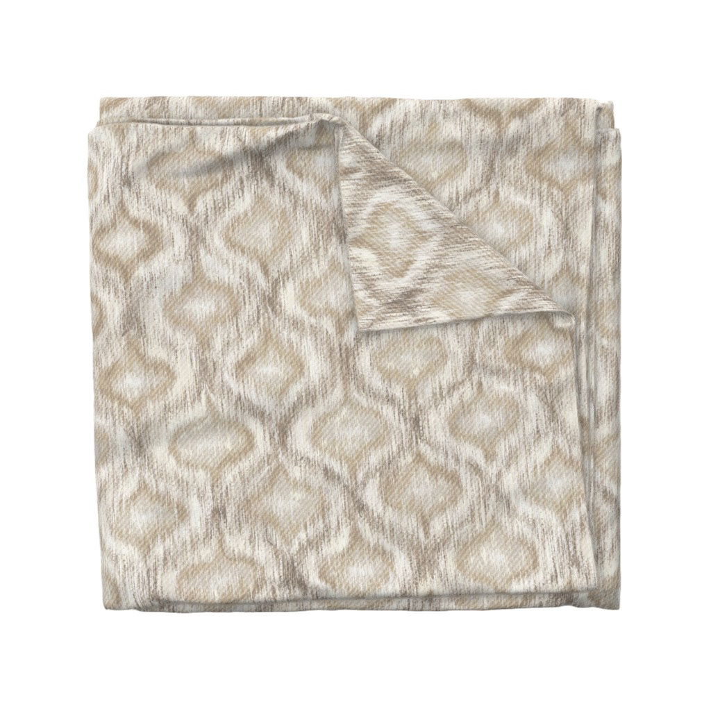 Folded fabric swatch of Boho Style Ikat Ogee in natural cream, showing the allover ogee repeat pattern, by Lemon Dessin