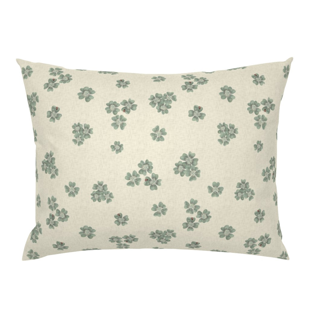 Square cushion cover in Clover Scatter cream colourway with hand-painted sage clover motifs, styled on a white background