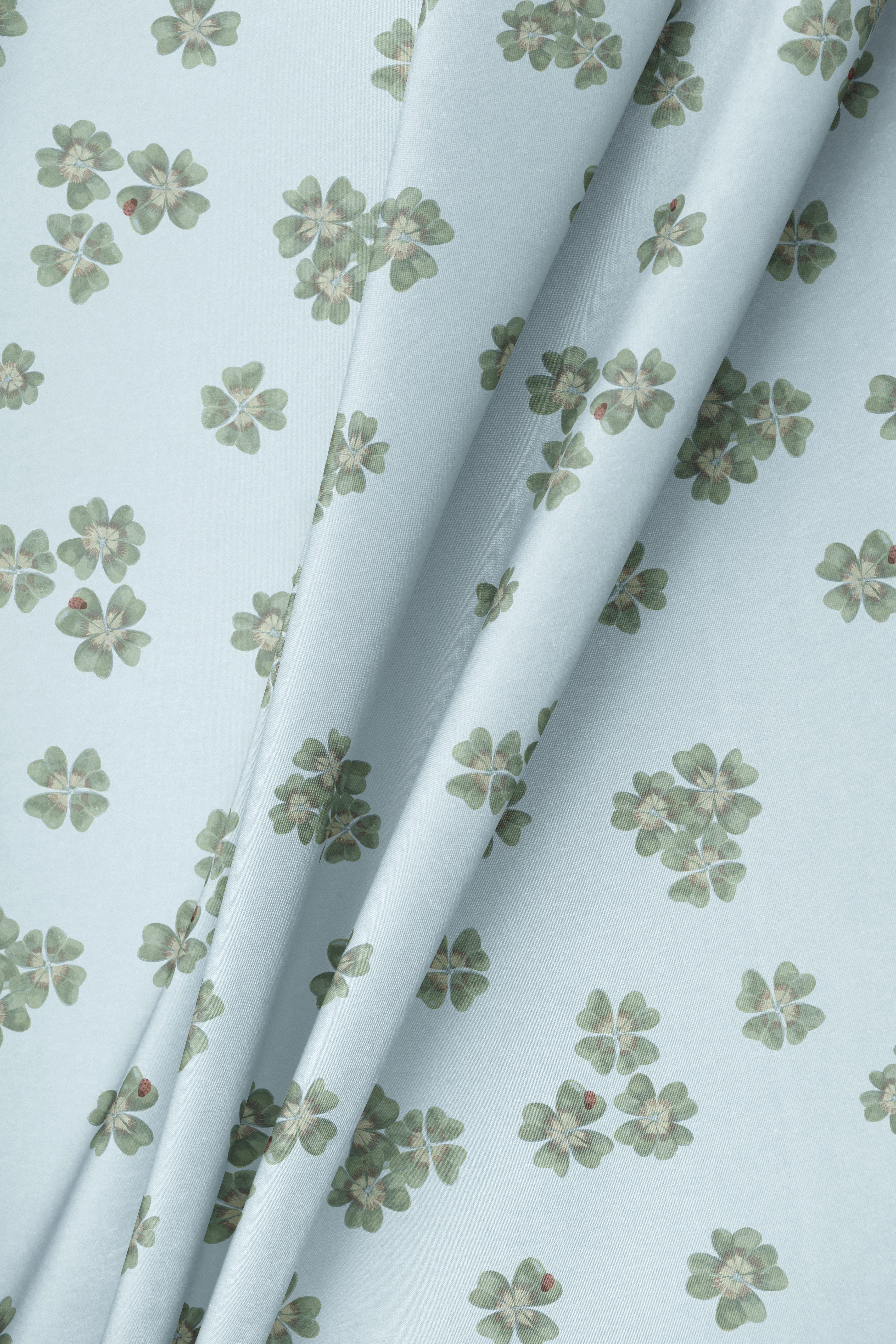 Draped fabric in Clover Scatter powder blue colourway draped to show the botanical scatter repeat
