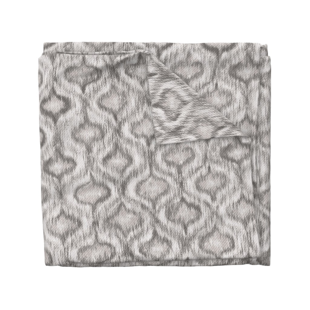 Folded fabric swatch of Boho Style Ikat Ogee in soft grey, showing the allover ogee repeat pattern, by Lemon Dessin