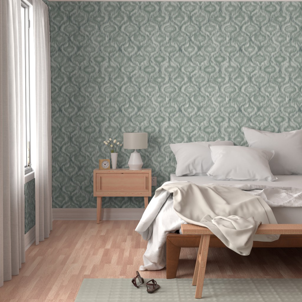 edroom with dusty teal ikat ogee wallpaper on the feature wall behind a low timber bed, white linen and a calm light-filled interior