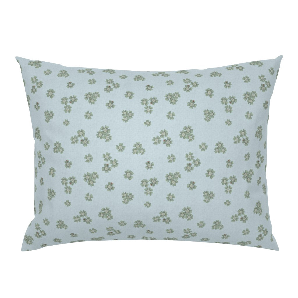 Pillowcase in Clover Scatter powder blue colourway with sage green clover motif, on a white background