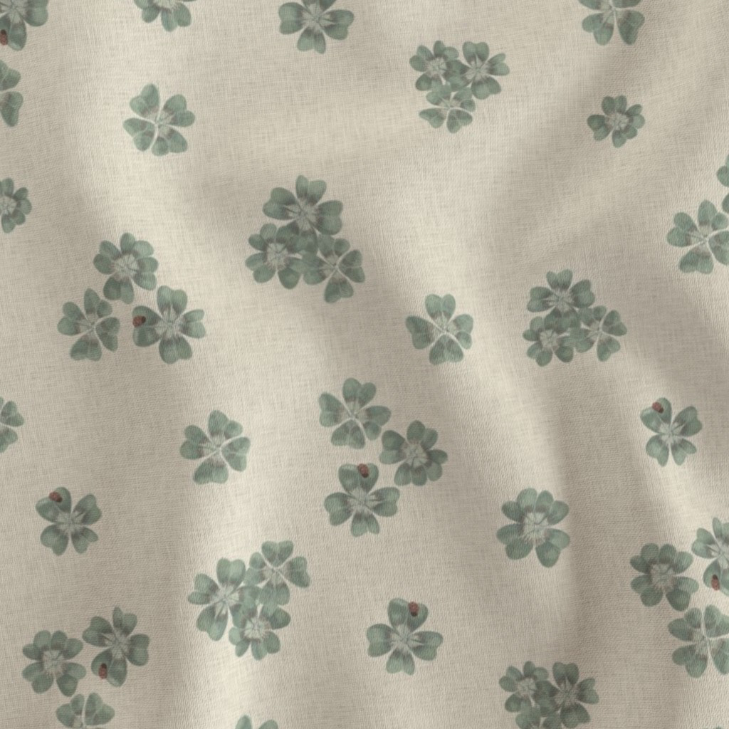 Flat fabric swatch showing Clover Scatter repeat pattern in cream colourway, sage green hand-painted clover motifs on warm ivory ground