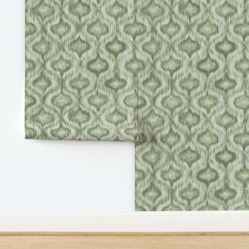 Sage green ikat ogee wallpaper panel leaning against a light interior wall, showing the soft earthy colourway at scale for a neo japandi or cottagecore bedroom
