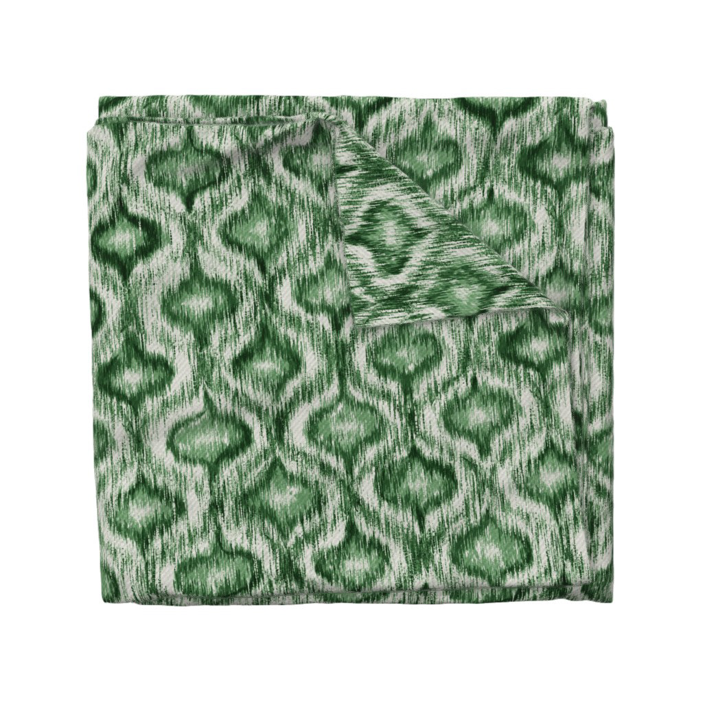 Folded fabric swatch of Boho Style Ikat Ogee in forest green, showing the allover ogee repeat pattern, by Lemon Dessin