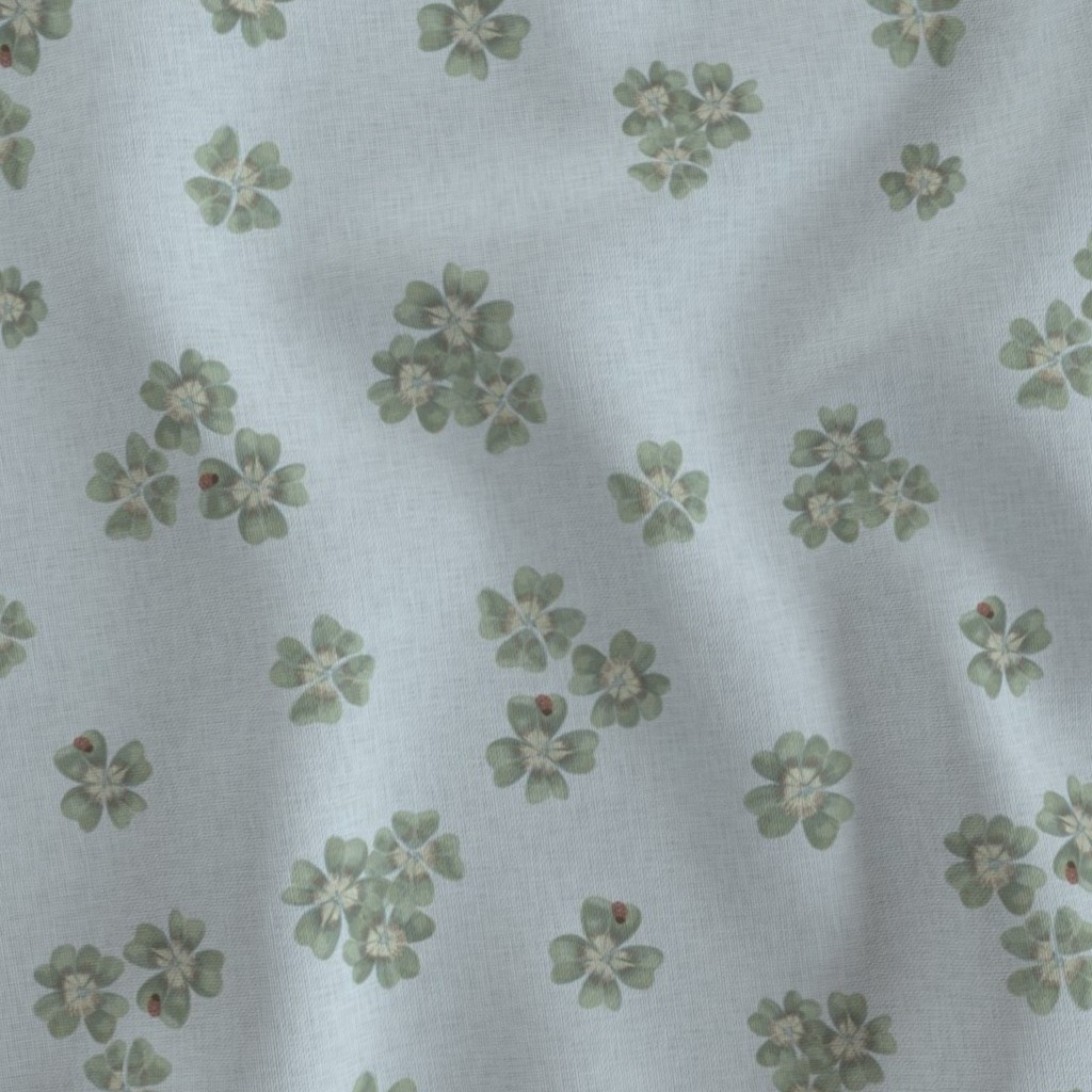 Flat fabric swatch showing Clover Scatter repeat pattern in powder blue colourway, sage green clover motifs on cool blue ground
