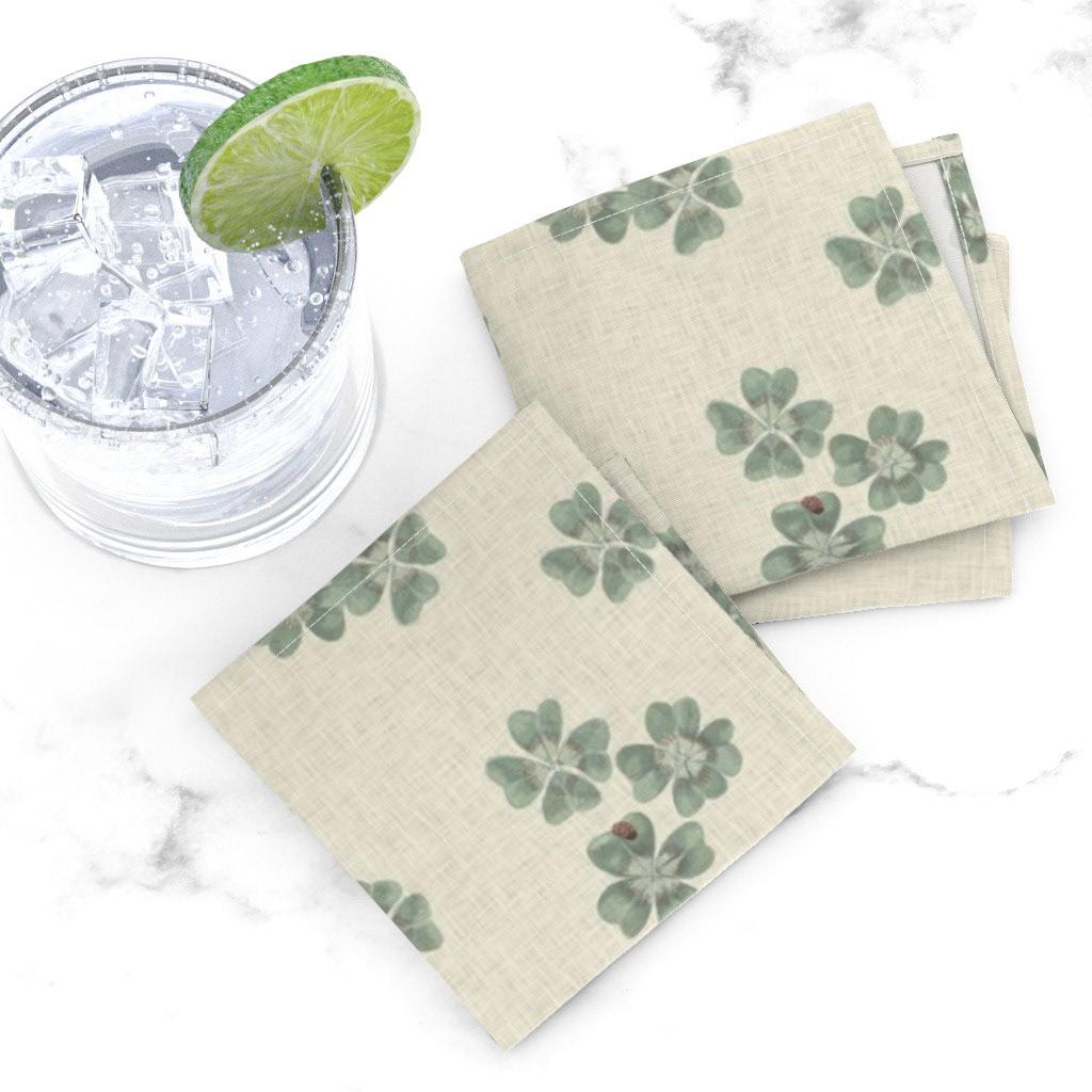 Lifestyle flat lay of Clover Scatter fabric in cream colourway beside a glass of water with lime, styled on a white surface